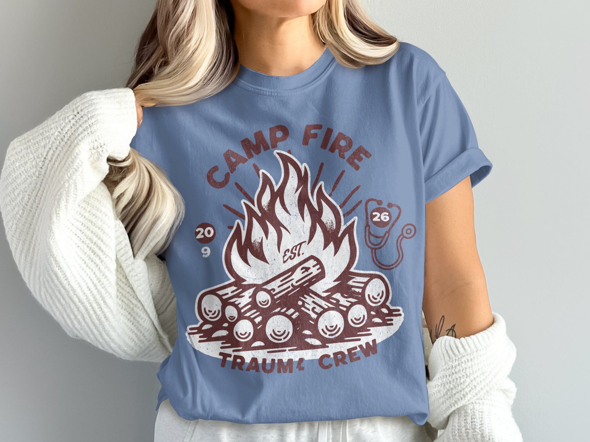 Camp Fire Trauma Crew t-shirt with campfire graphic and stethoscope detail.