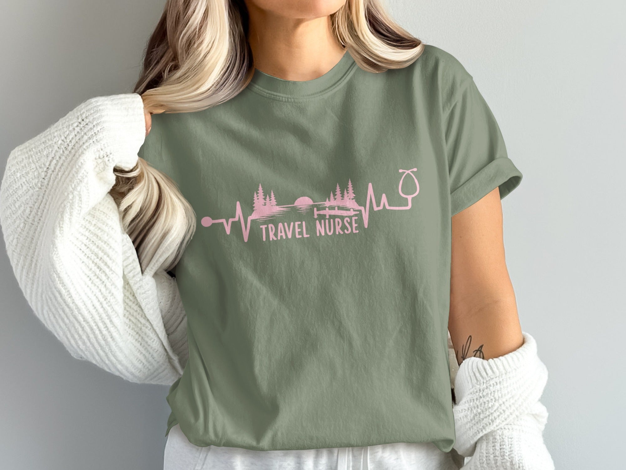 Olive green t-shirt with "TRAVEL NURSE" and a pink heartbeat line with trees.