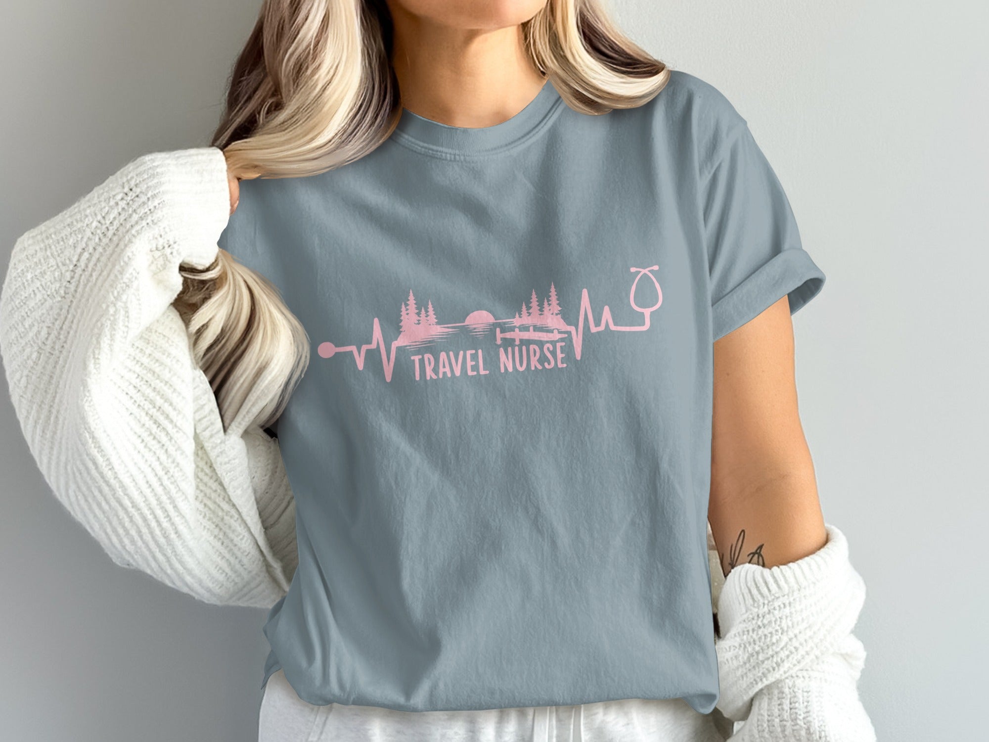 T-shirt with pink "Travel Nurse" text and a heartbeat line incorporating a landscape.