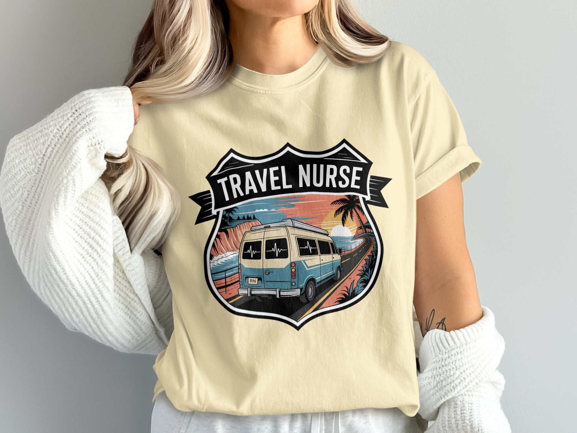 Beige t-shirt with "Travel Nurse" crest featuring a van and coastal landscape.