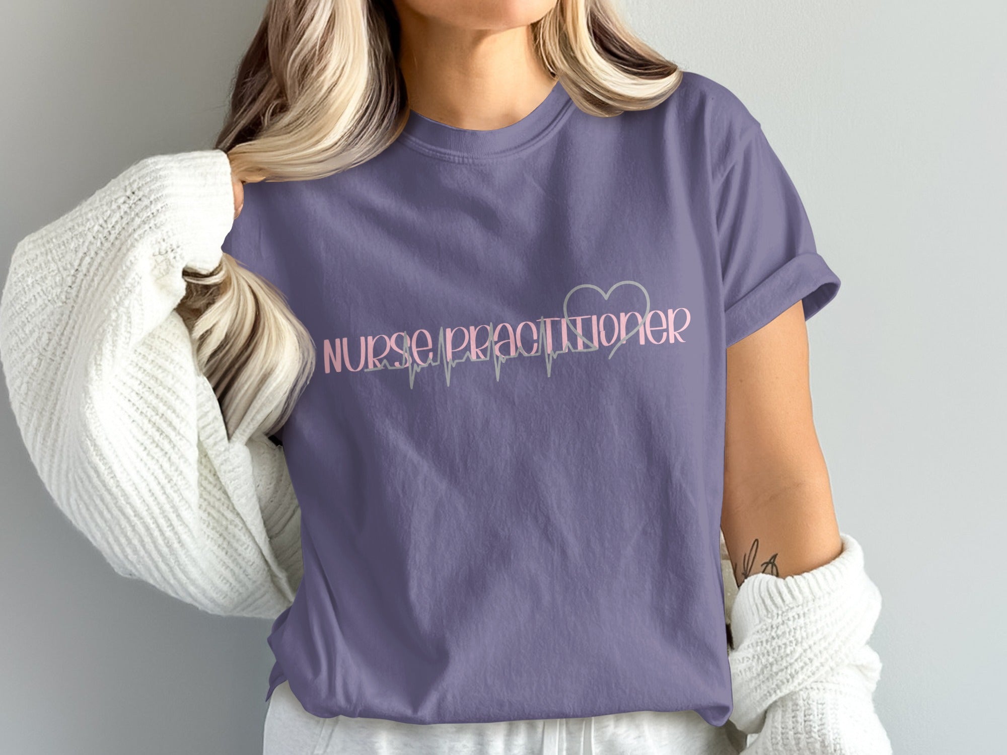 Purple t-shirt with "Nurse Practitioner" and heart with electrocardiogram graphic.