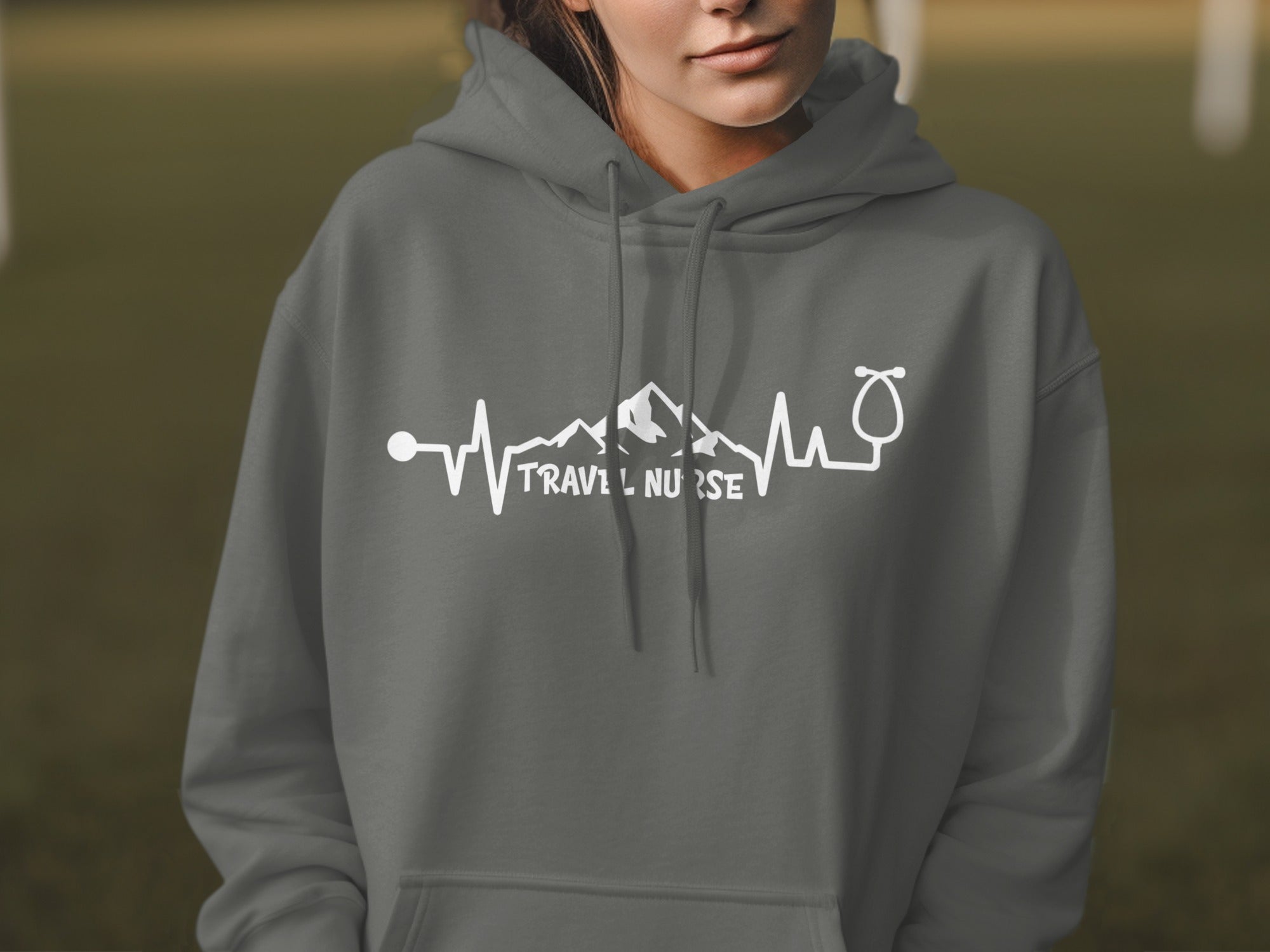 Grey hoodie with white "Travel Nurse" text, stethoscope, and mountain heartbeat graphic.