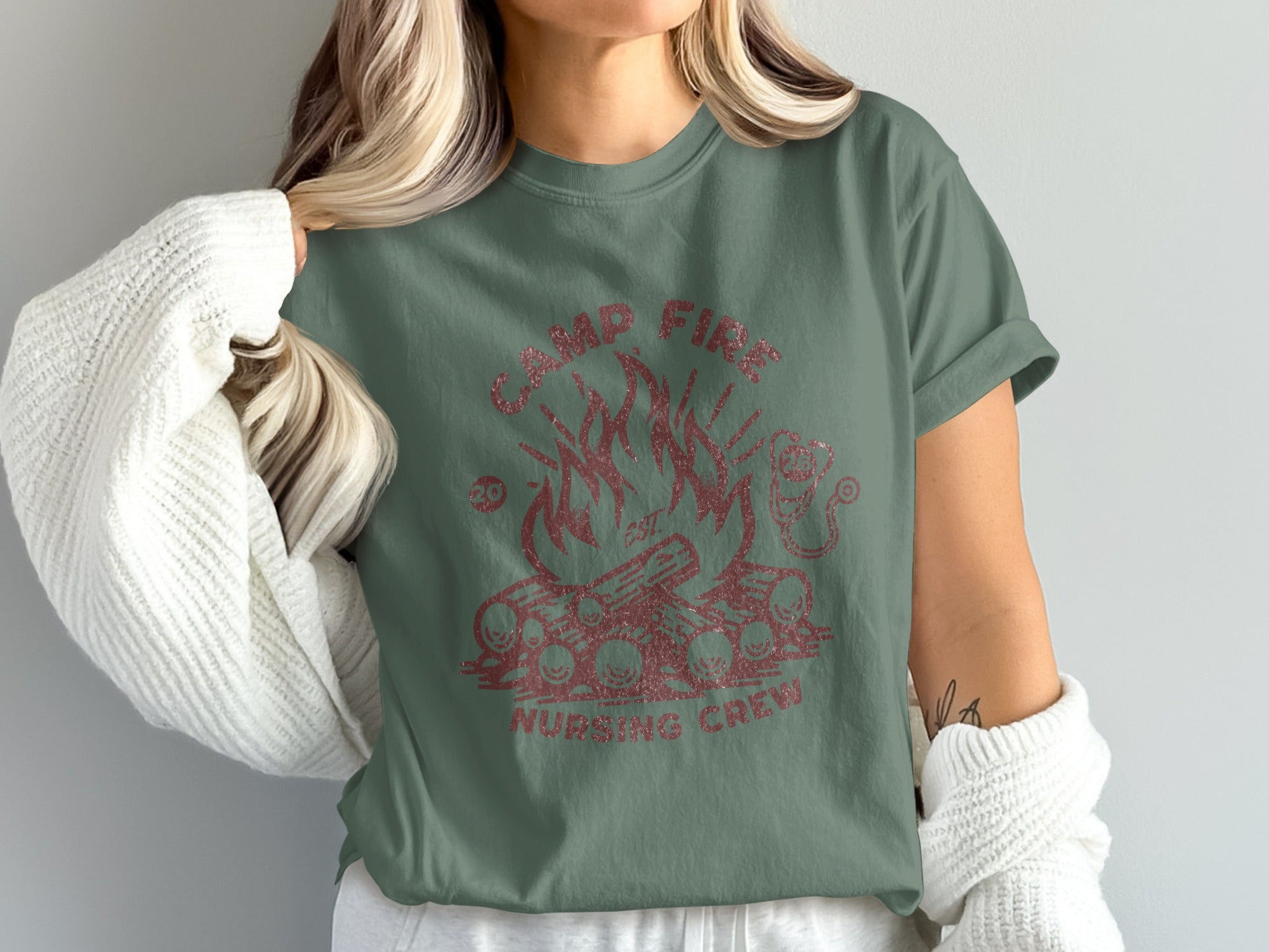 Green t-shirt with red glitter graphic of campfire and text "CAMP FIRE NURSING CREW".