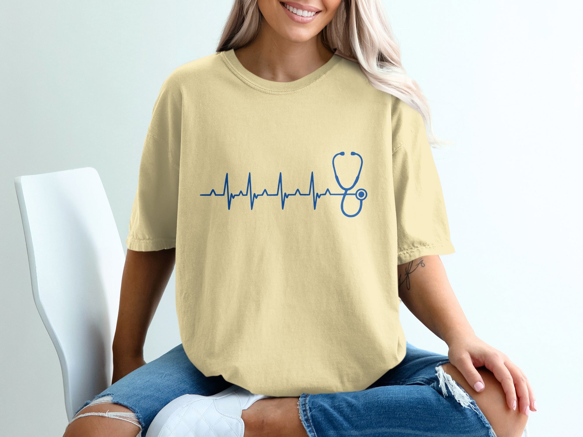 Yellow t-shirt with a blue stethoscope heartbeat graphic.