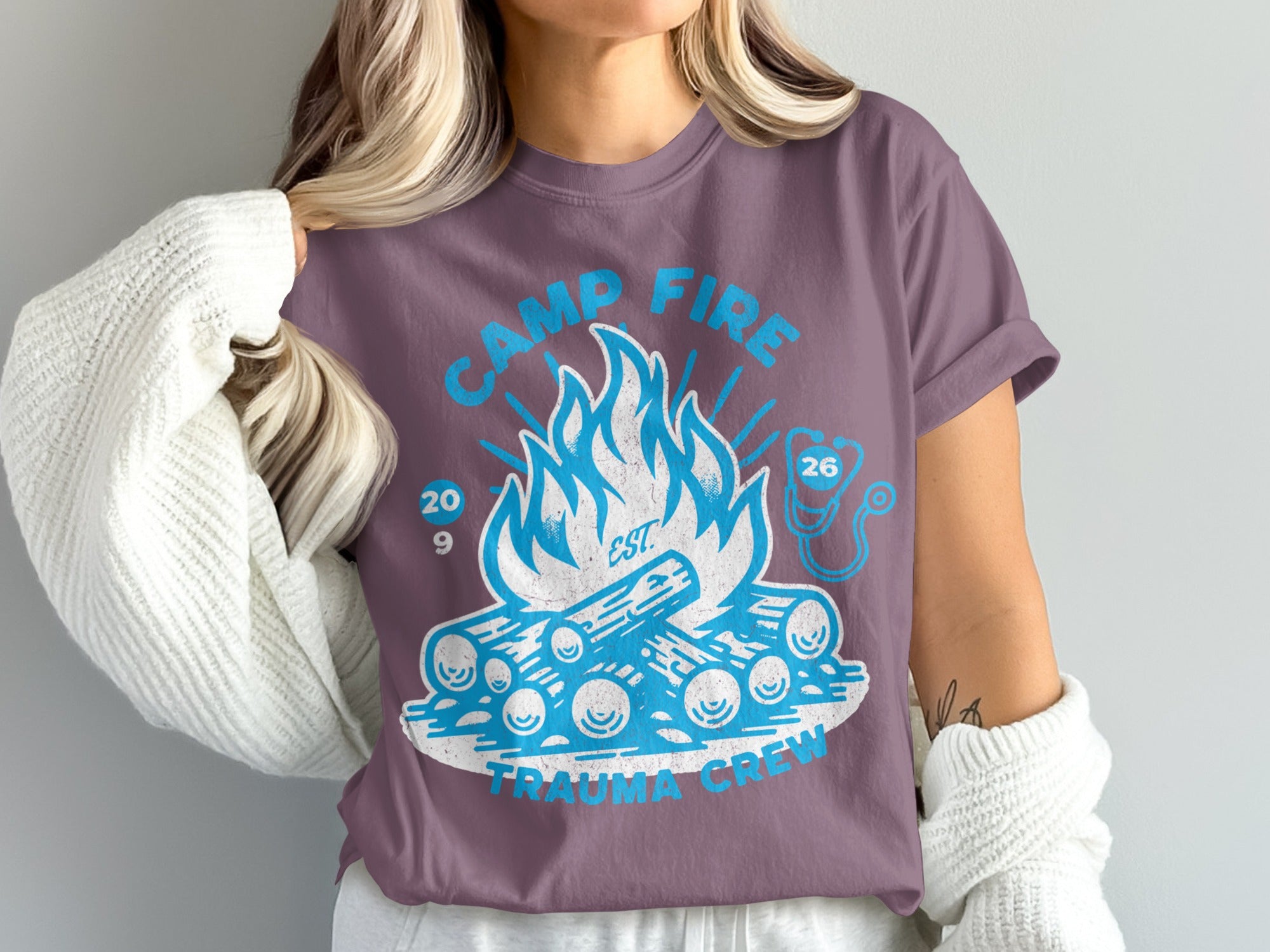 Camp Fire Trauma Crew 2029 blue graphic on purple t-shirt.