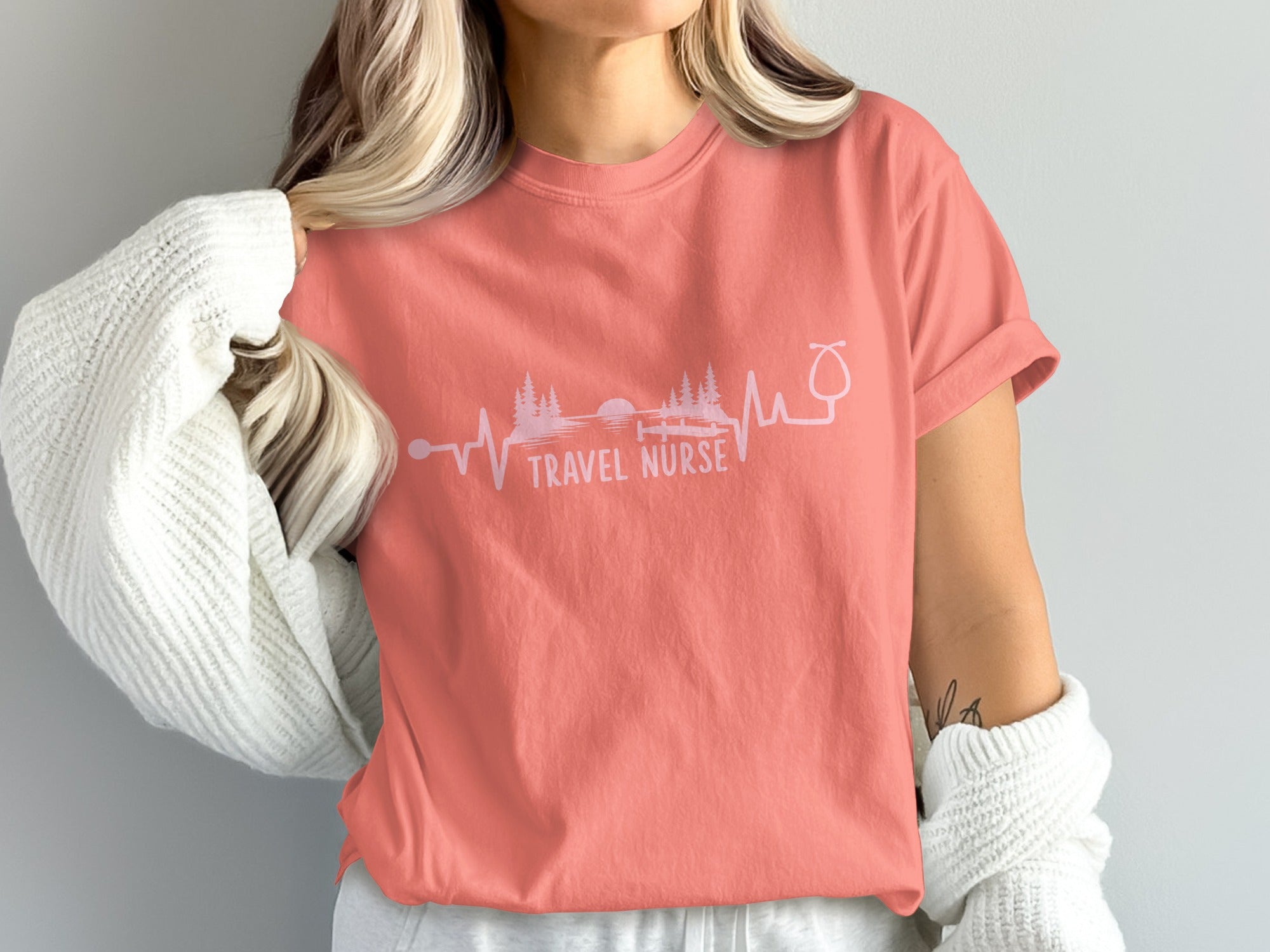 Coral t-shirt with "TRAVEL NURSE" text and a heartbeat line graphic.