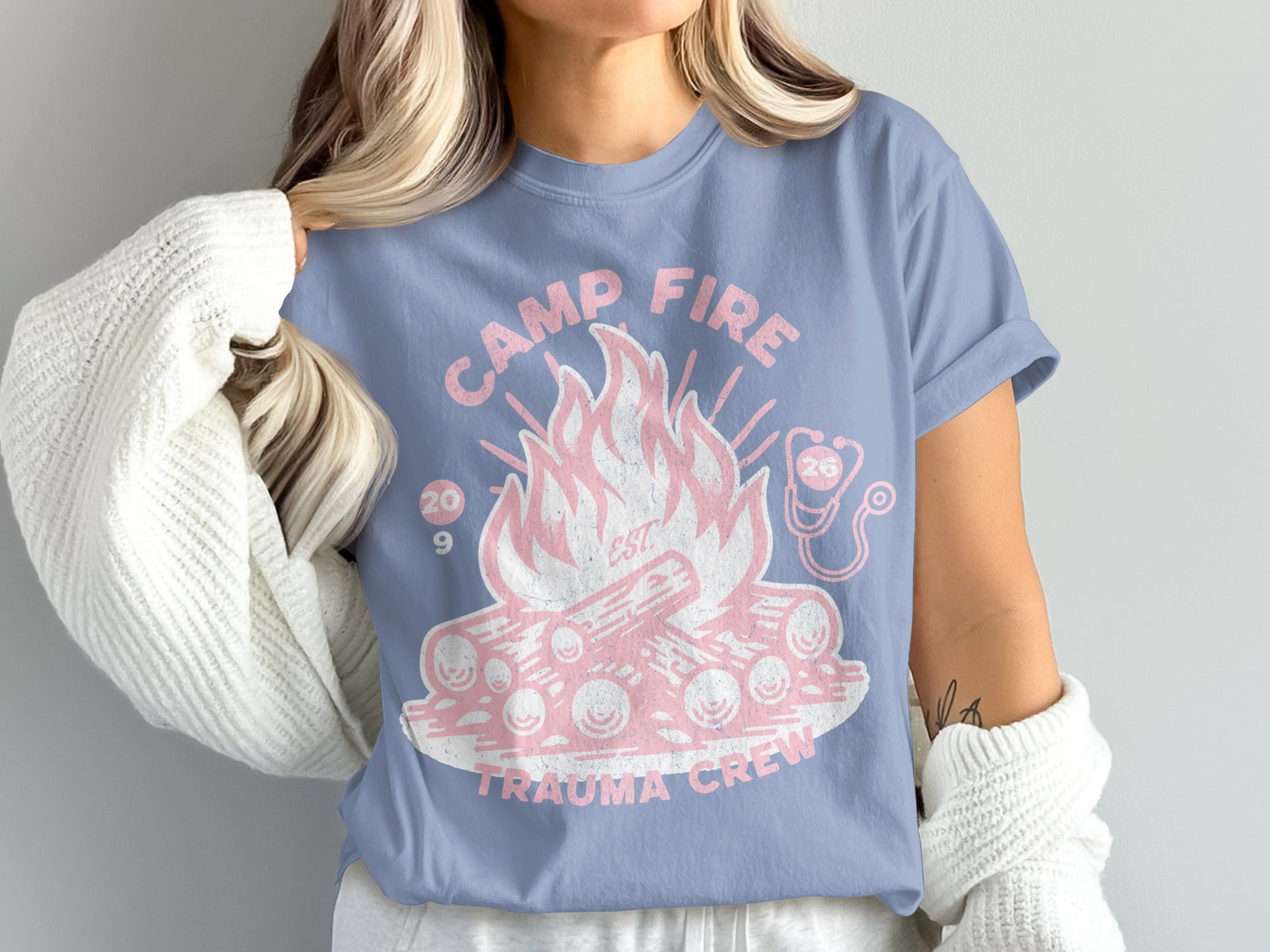 Light blue t-shirt with "Camp Fire Trauma Crew" and a graphic of a campfire.