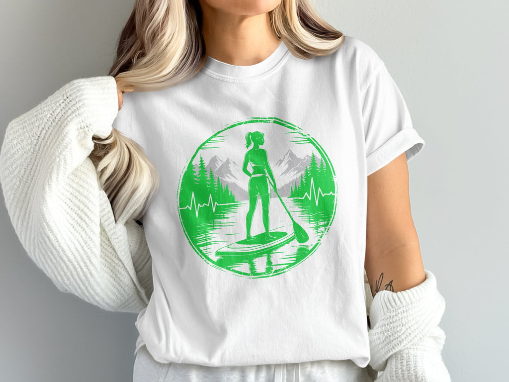 White t-shirt with green circular graphic of paddleboarder in mountains.