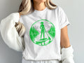 White t-shirt with green circular graphic of paddleboarder in mountains.