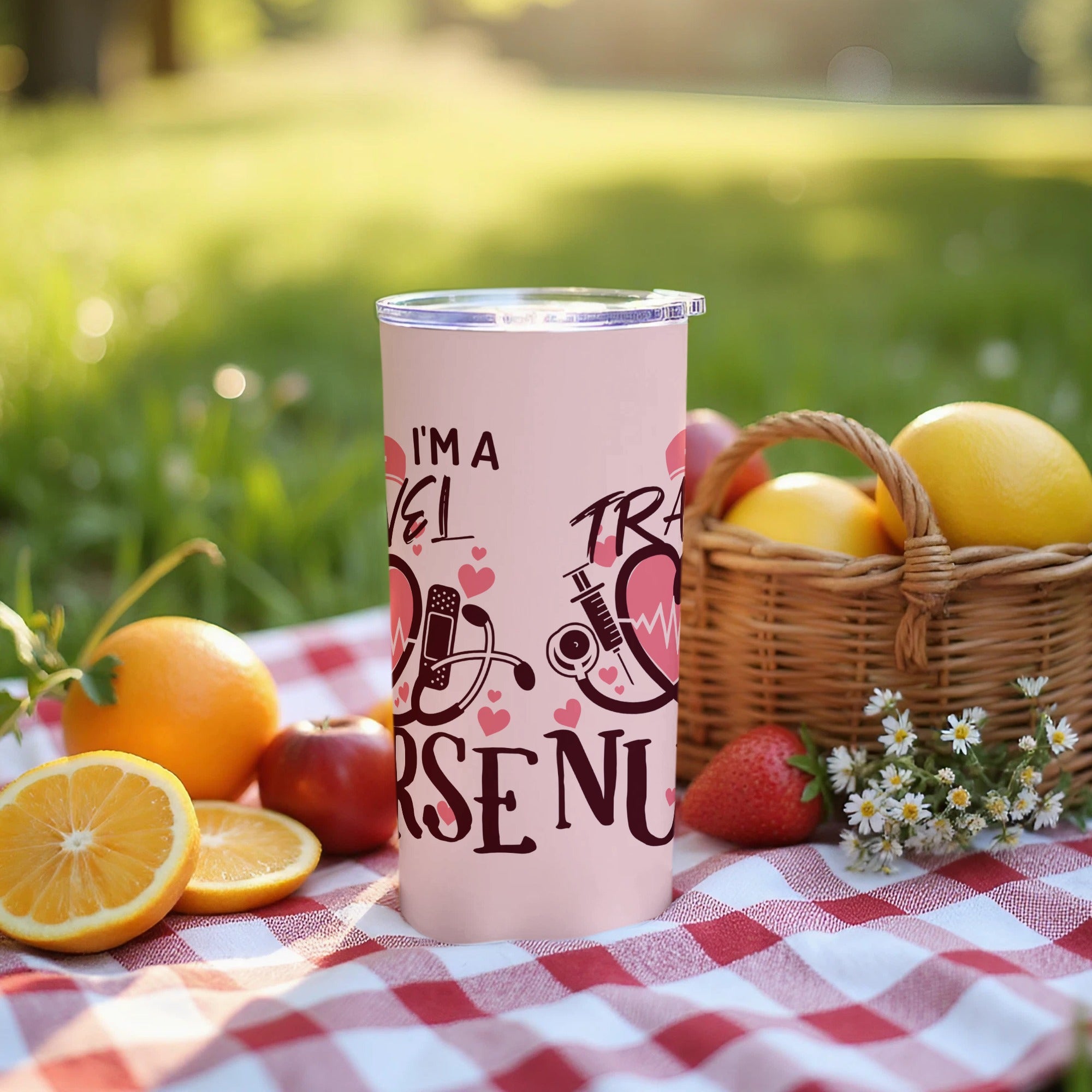 Pink tumbler with medical graphics and text "I'M A TRAVEL NURSE" on a picnic blanket.