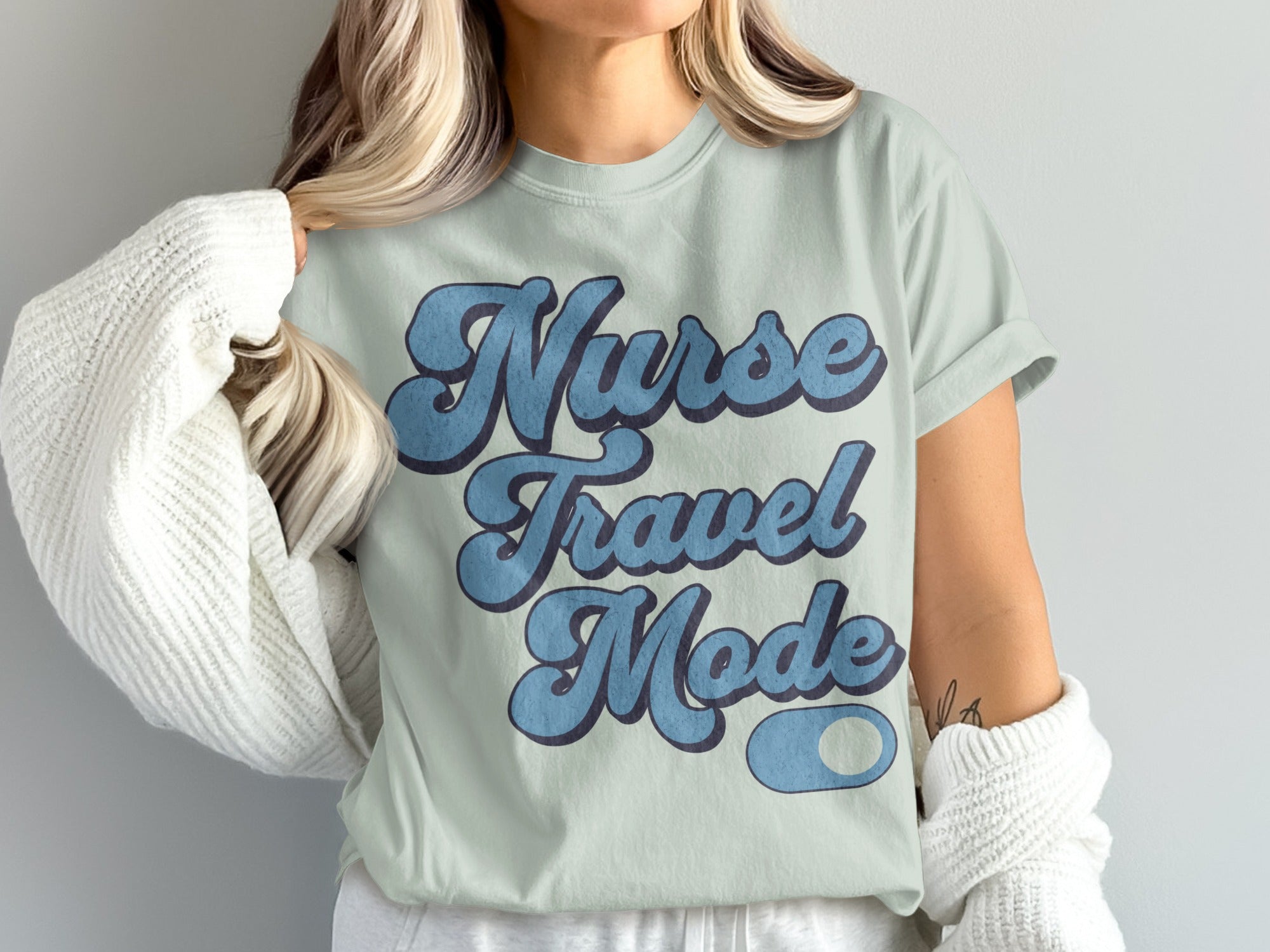 Light blue t-shirt with "Nurse Travel Mode" text in retro blue font.