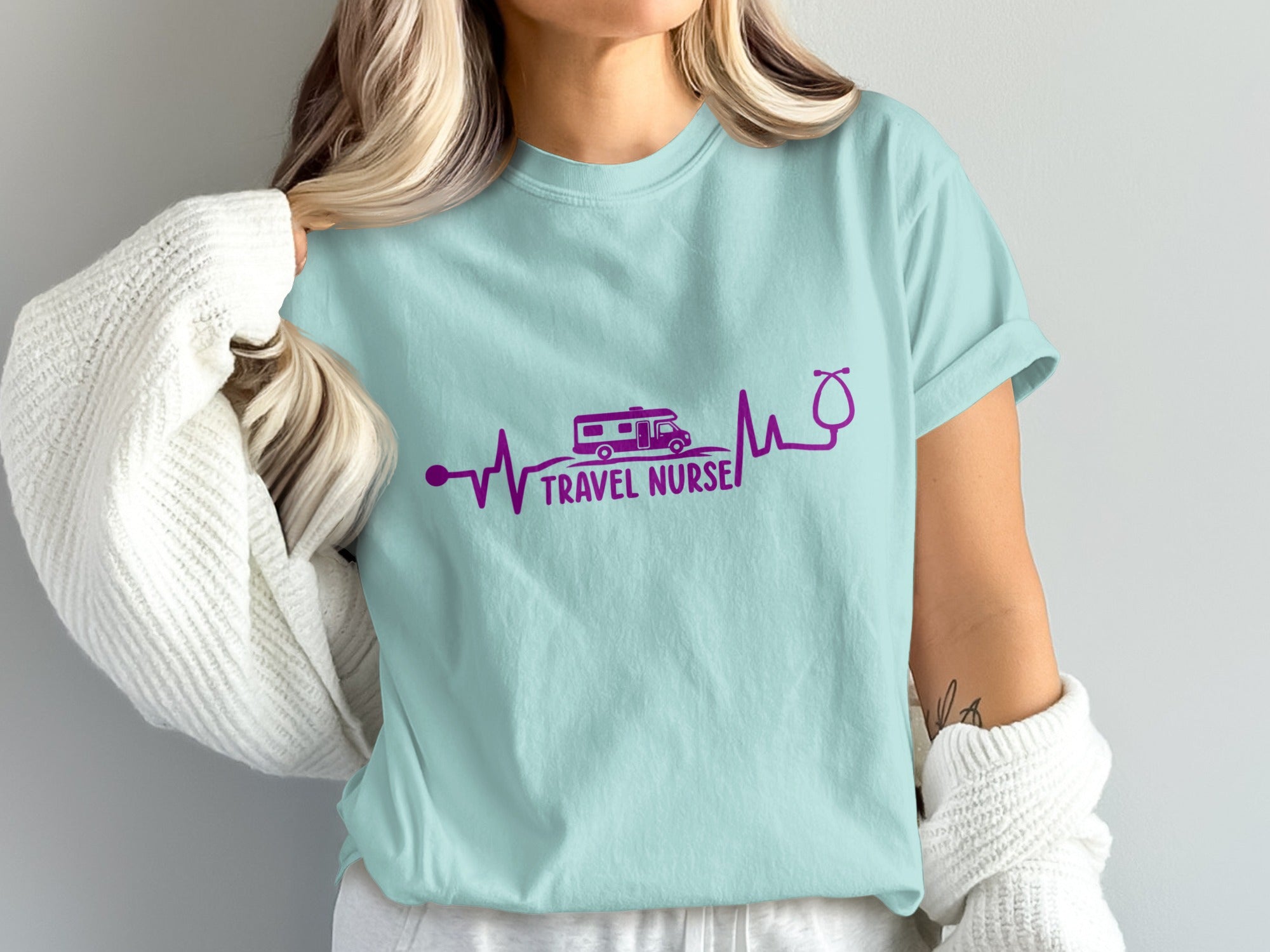 Light blue t-shirt with a purple heartbeat design, camper, and stethoscope.
