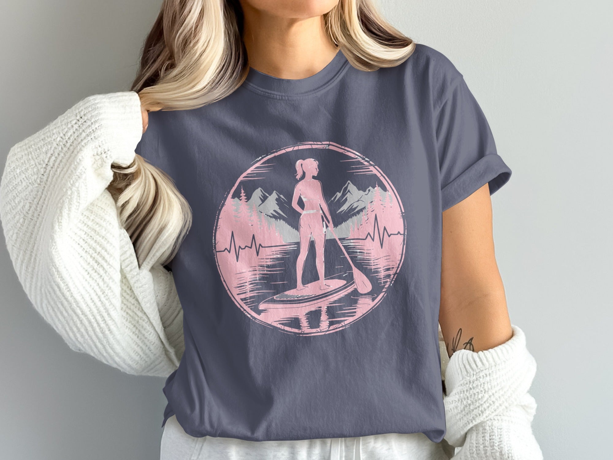 Circular graphic of a paddleboarder with mountains and trees, against a heartbeat line.
