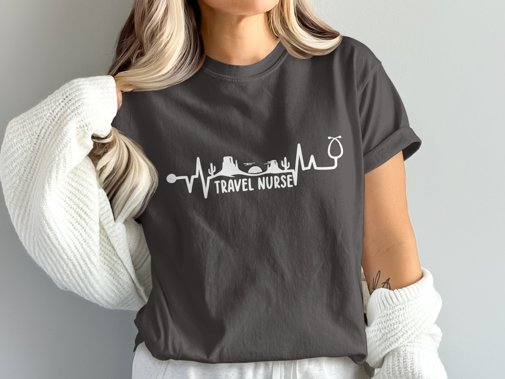 Dark t-shirt with white stethoscope heartbeat graphic and "TRAVEL NURSE" text.