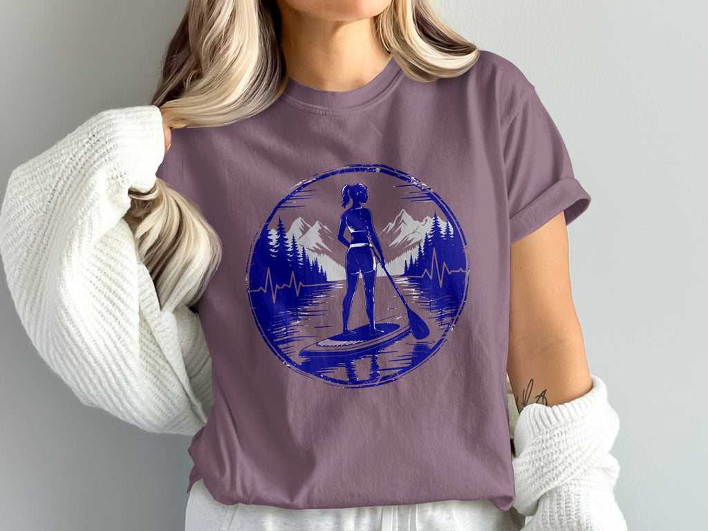Woman in purple t-shirt with paddleboarder silhouette mountain graphic.