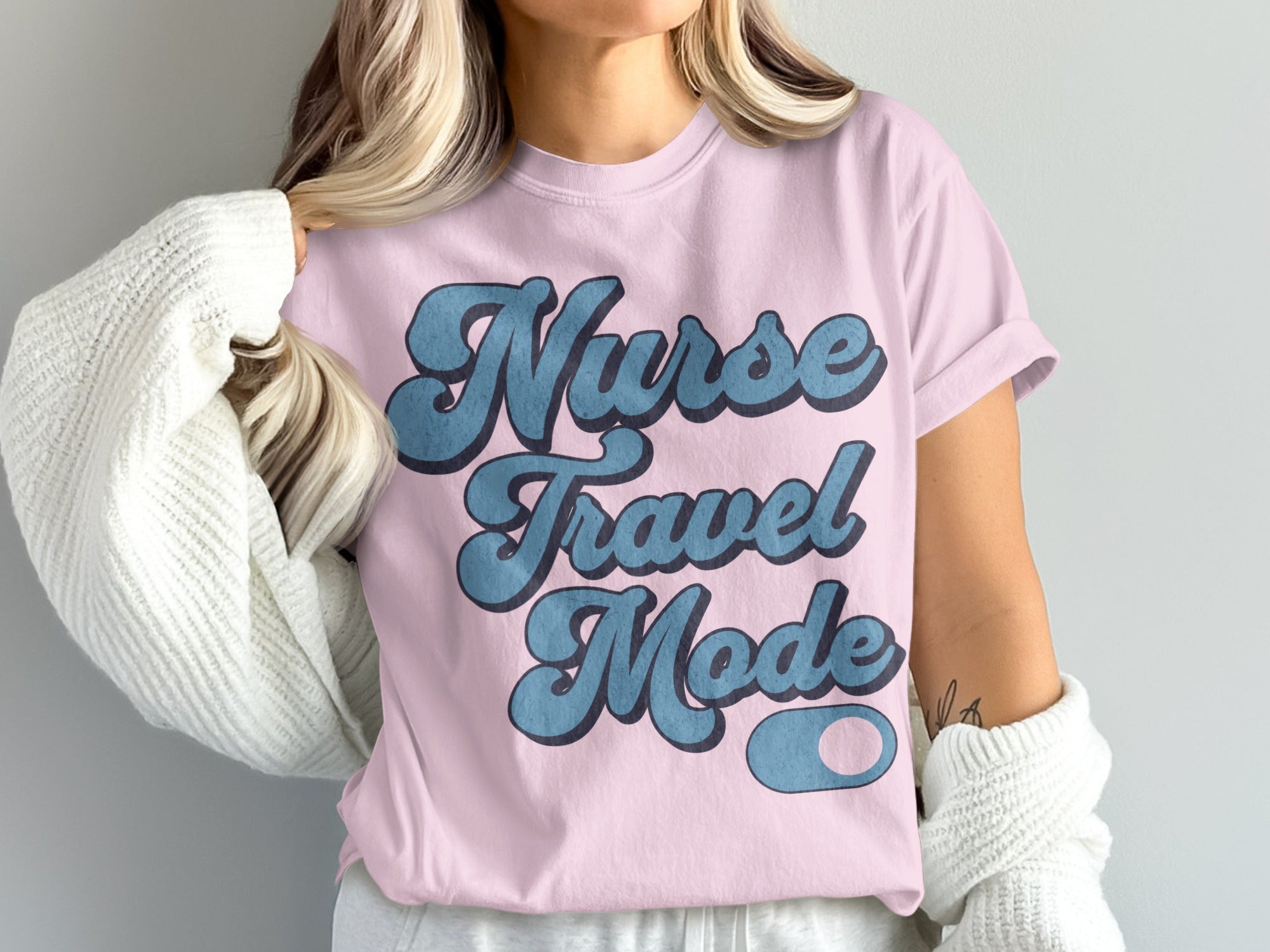 Pink t-shirt with "Nurse Travel Mode" text in blue retro font.