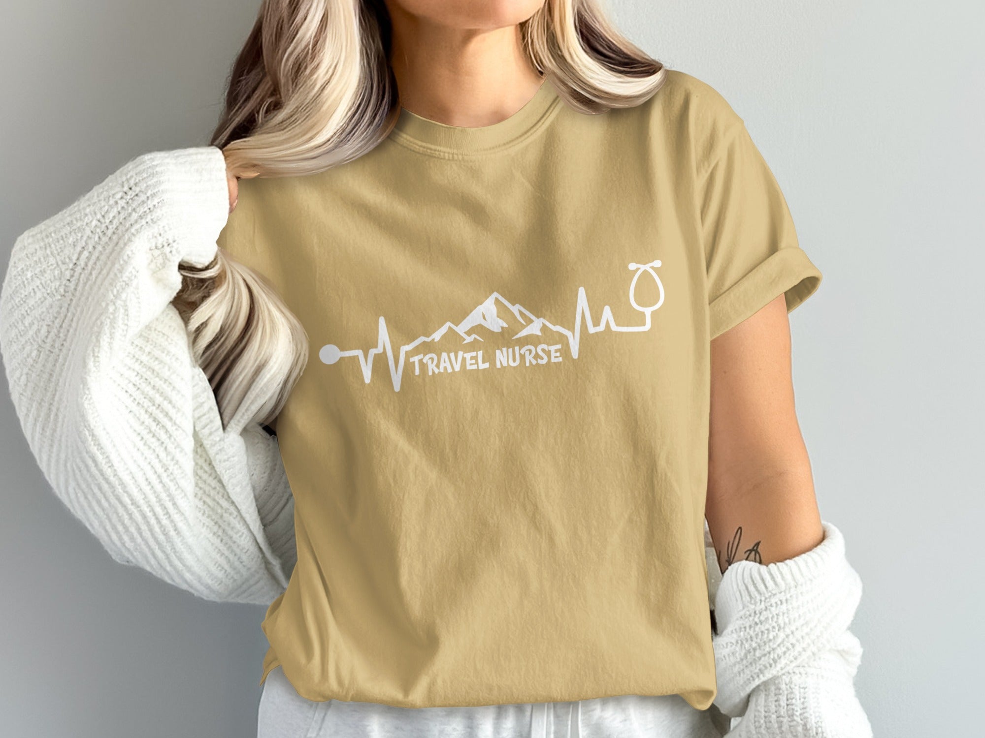 Tan t-shirt with "TRAVEL NURSE" text and stethoscope heartbeat graphic.