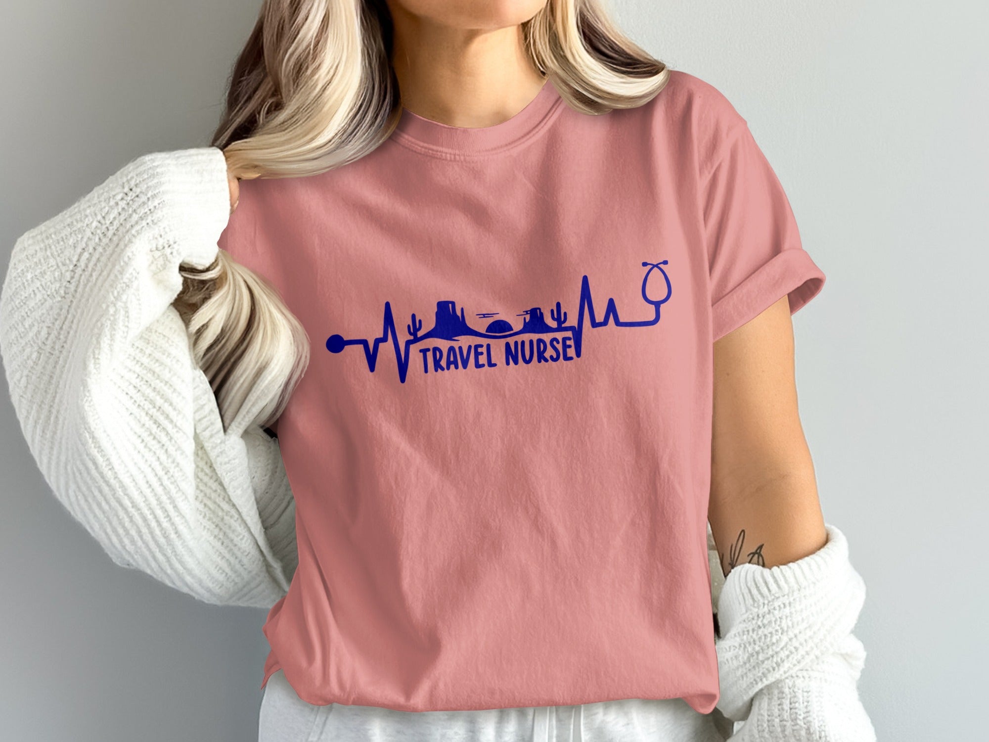 Pink t-shirt with "TRAVEL NURSE" text and desert landscape heartbeat graphic.