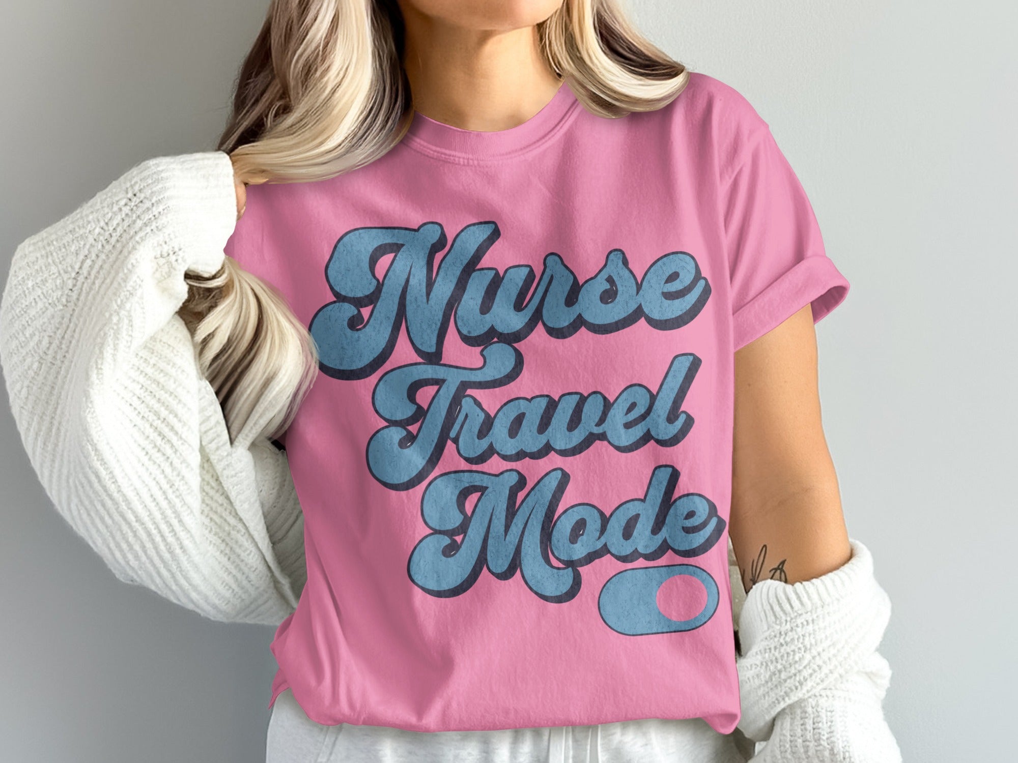 Pink t-shirt with "Nurse Travel Mode" text in blue script.