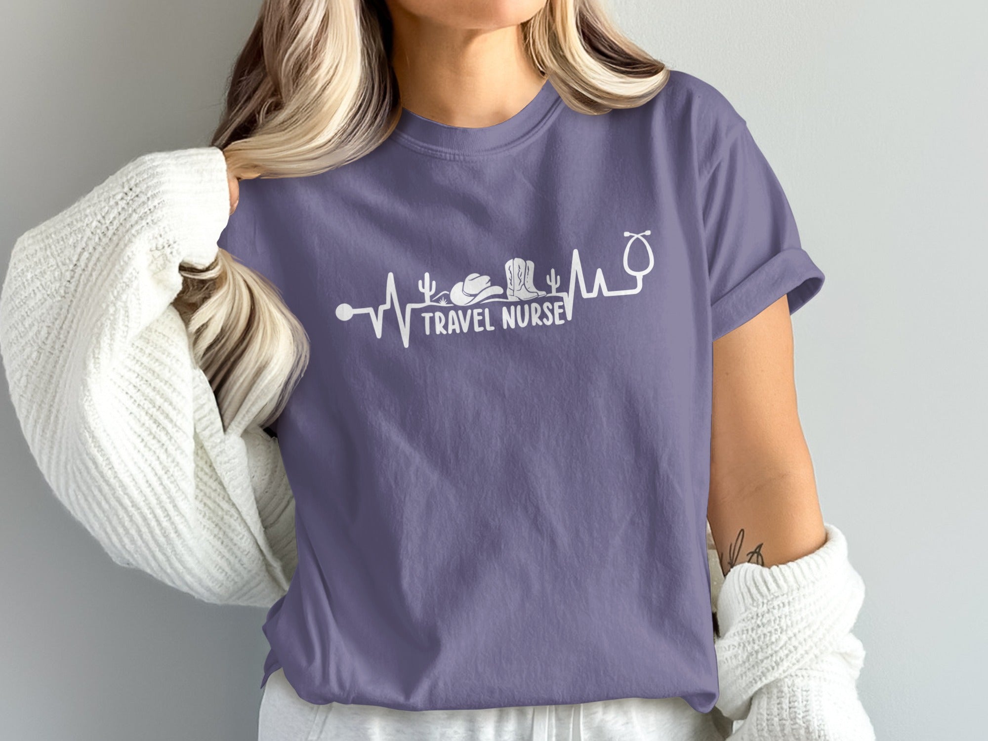 Purple t-shirt with stethoscope and desert graphic, "Travel Nurse" text.