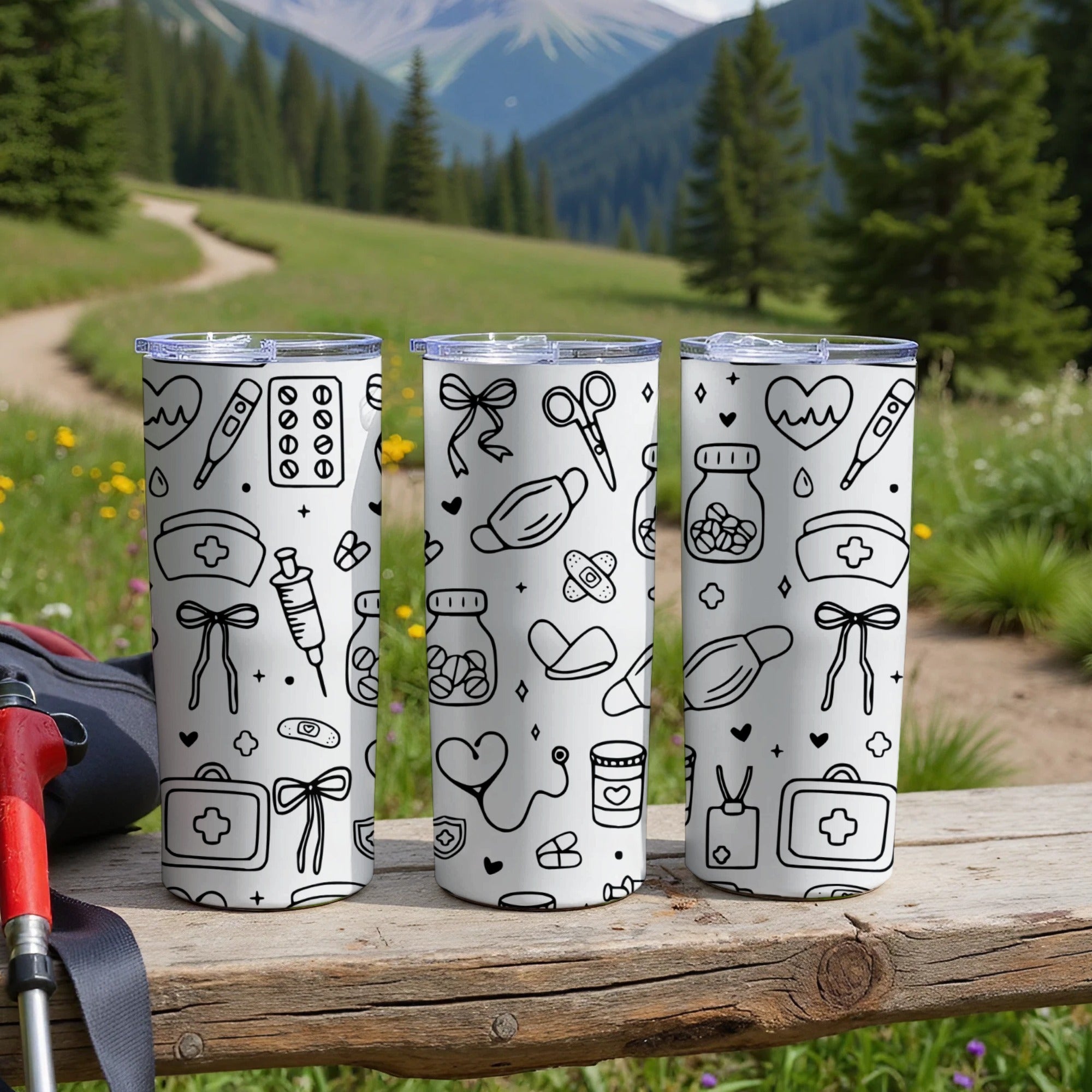 Three white tumblers with medical icons on a wooden surface.