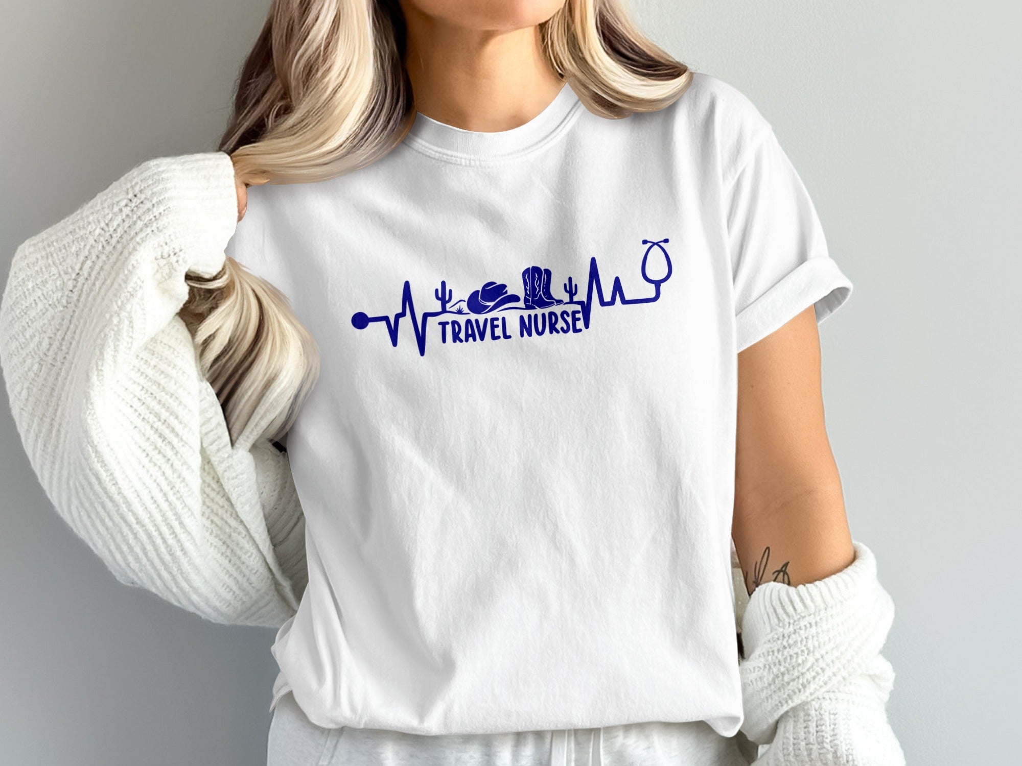 White t-shirt with "Travel Nurse" and stethoscope graphic in blue.