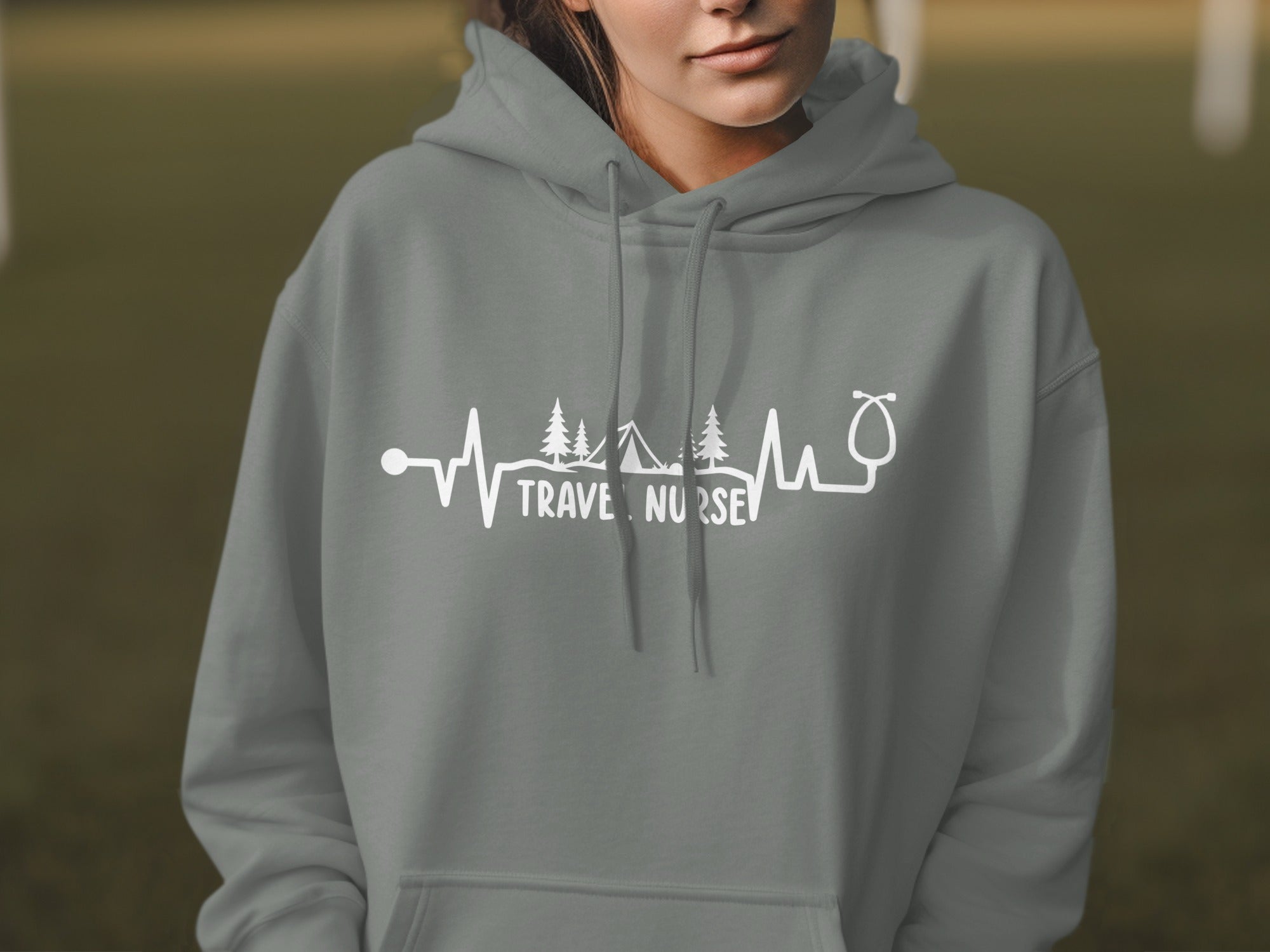 Grey hoodie with "TRAVEL NURSE" text and heartbeat, trees, and stethoscope graphic.