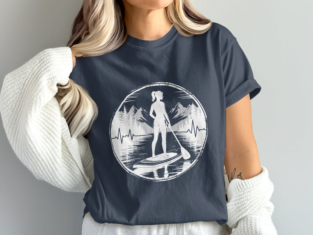 Woman wearing dark t-shirt with paddleboarder silhouette in circular nature graphic.