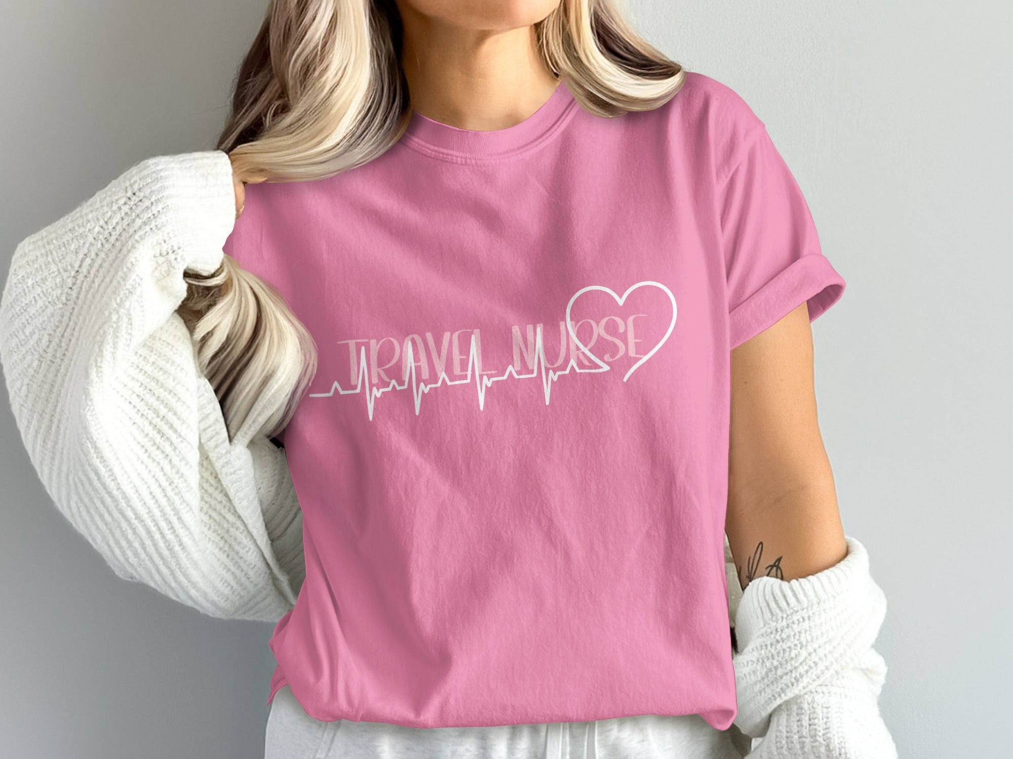 Pink t-shirt with "TRAVEL NURSE" text and a heart with a heartbeat line.