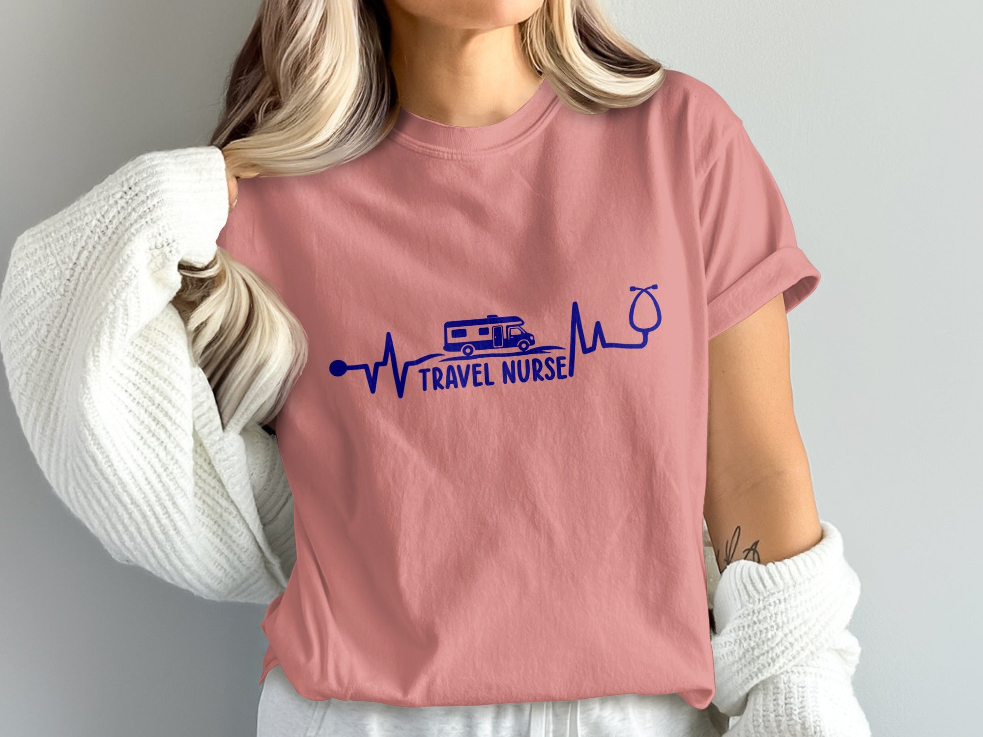 Pink t-shirt with blue electrocardiogram design, RV, and stethoscope, reading "TRAVEL NURSE".