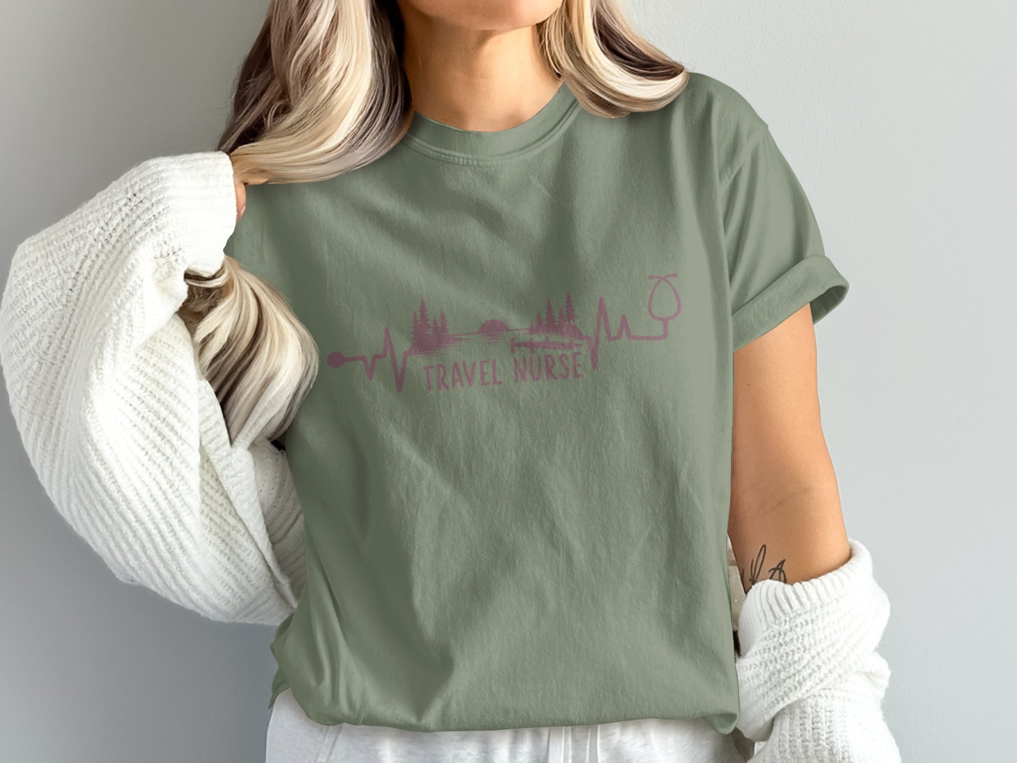 Olive green t-shirt with "TRAVEL NURSE" and a nature-themed electrocardiogram design.