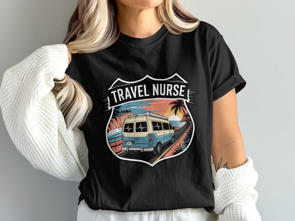 Black t-shirt graphic featuring a vintage van driving towards a sunset over the ocean with "TRAVEL NURSE" text.