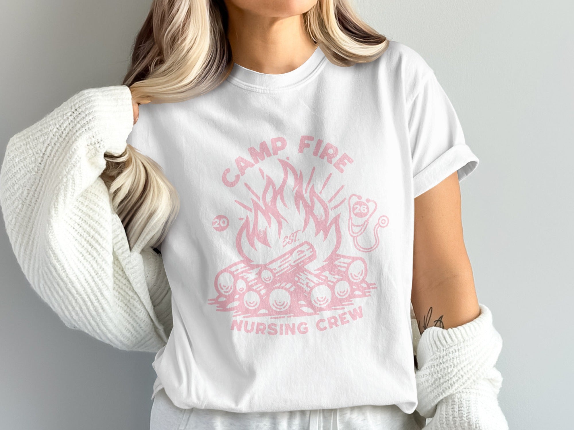 White t-shirt with pink campfire and "Camp Fire Nursing Crew" text.