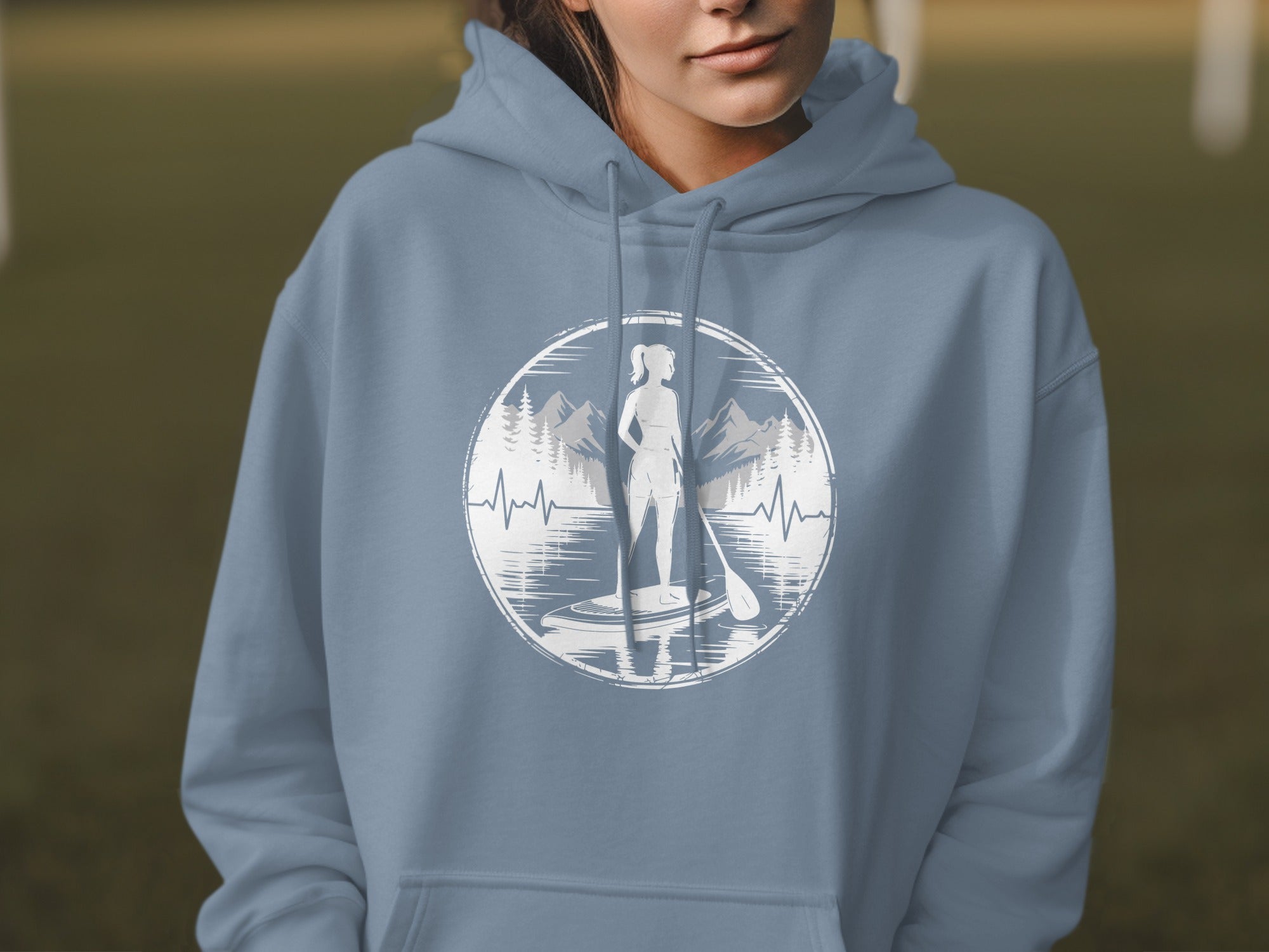 Woman in blue hoodie with paddleboarder graphic on chest.