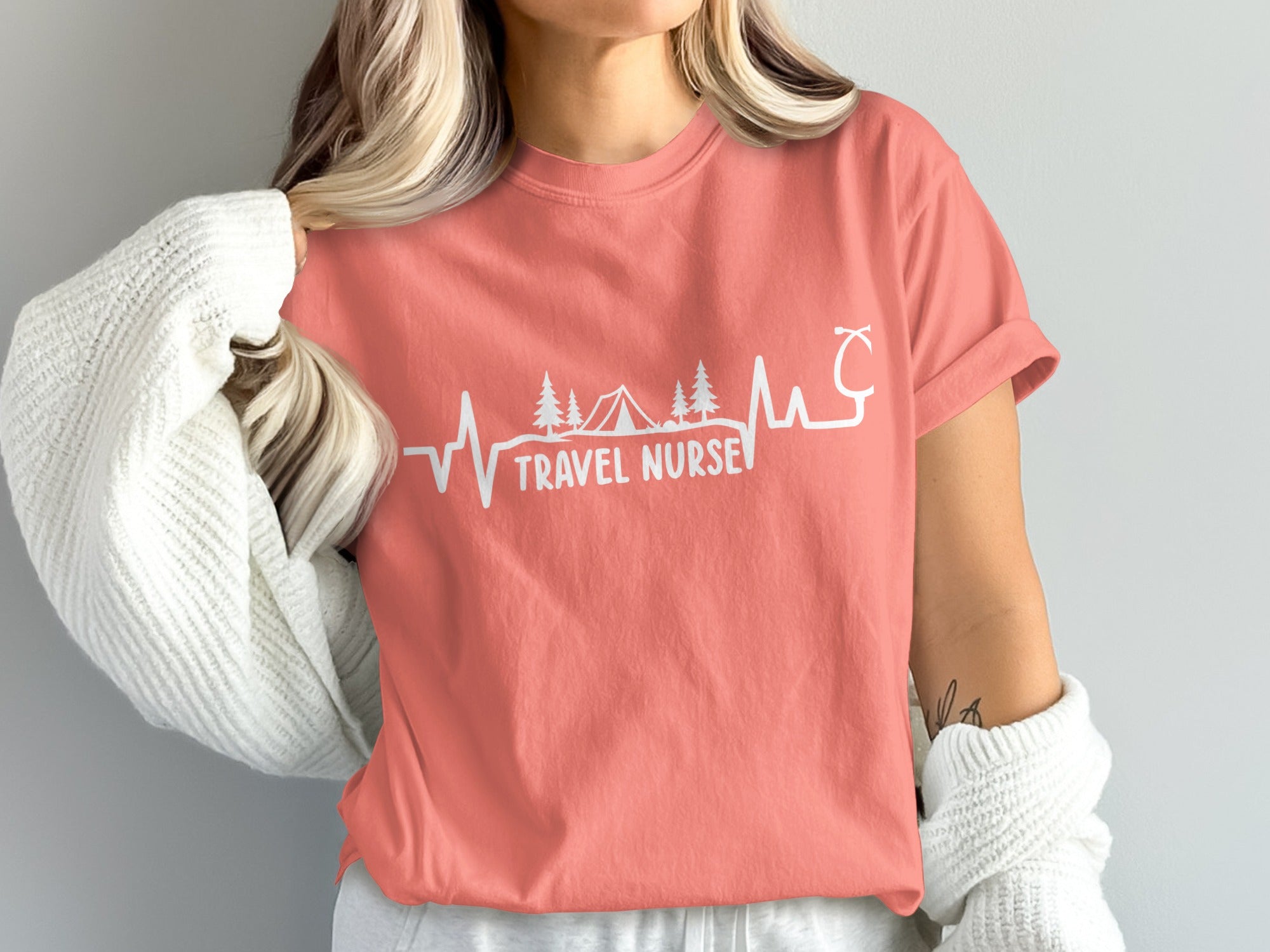 Coral t-shirt with "Travel Nurse" text, camping graphic, and stethoscope.