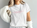White t-shirt with "Travel Nurse" in pink, featuring a stethoscope and heartbeat.