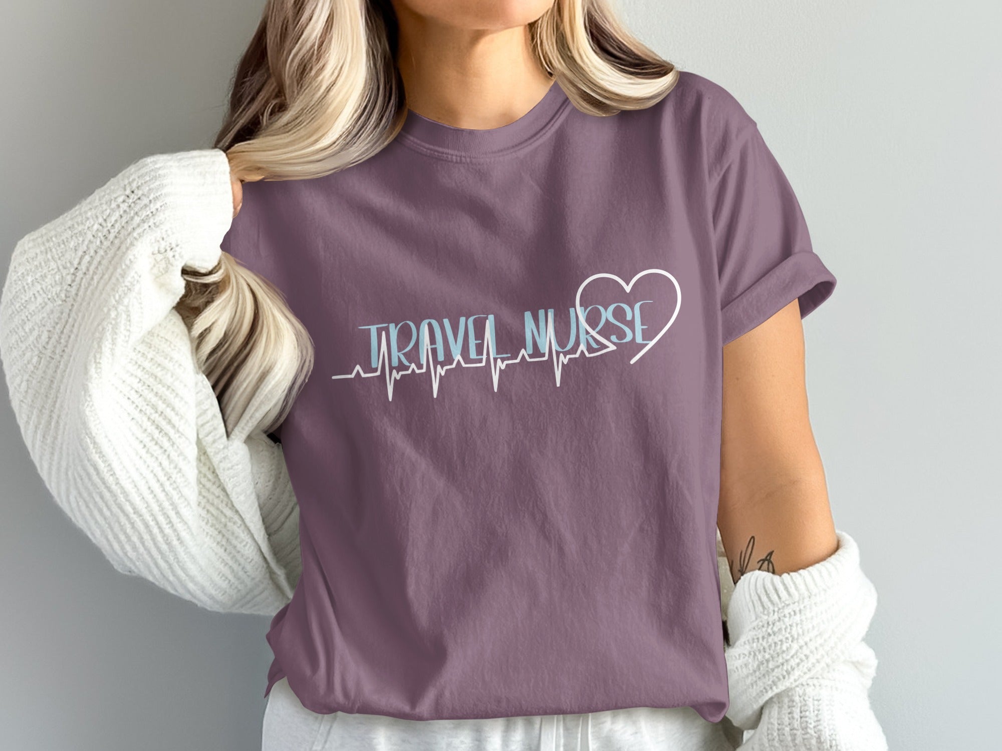 Purple t-shirt with "TRAVEL NURSE" in white and blue lettering over a heart monitor line.