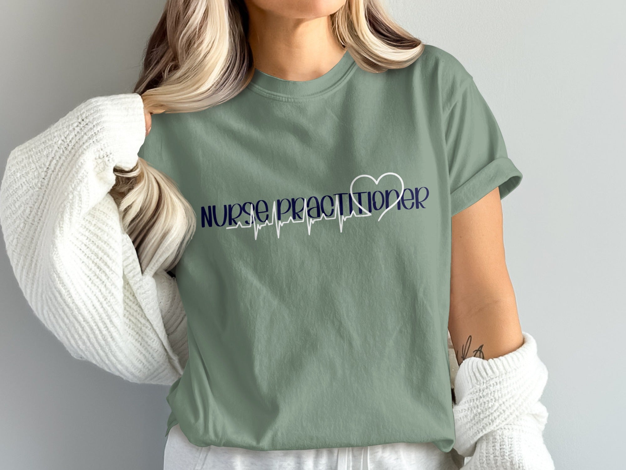 Sage green t-shirt with "Nurse Practitioner" and a heartbeat graphic.