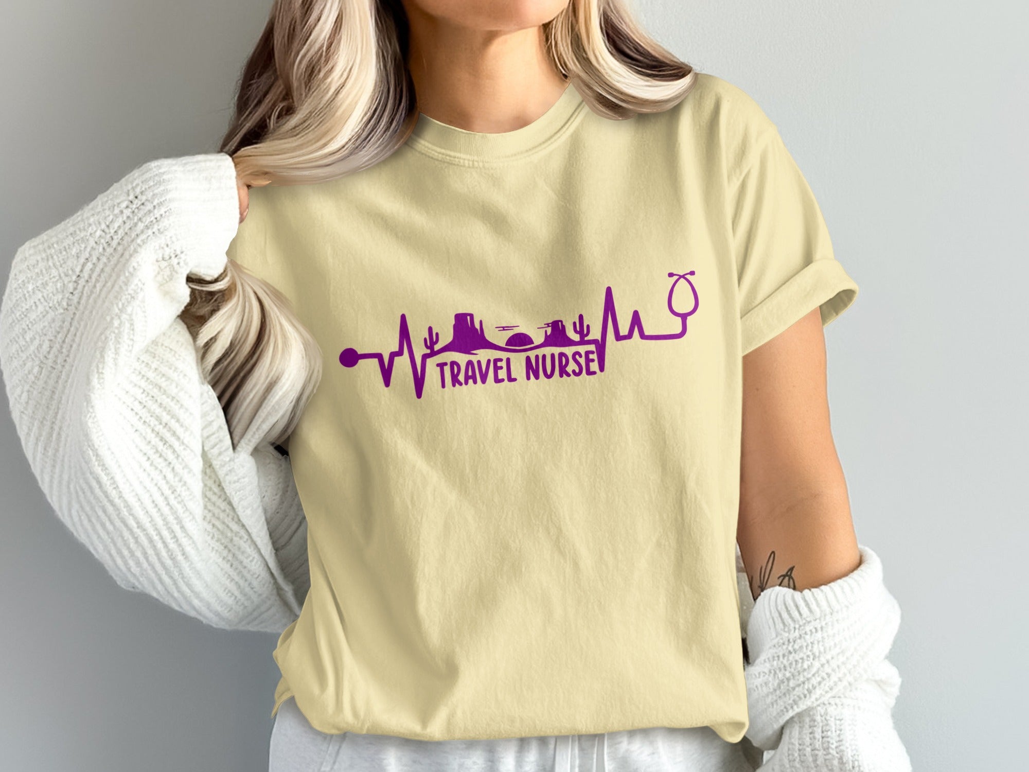 Light yellow t-shirt with purple travel nurse graphic and stethoscope.