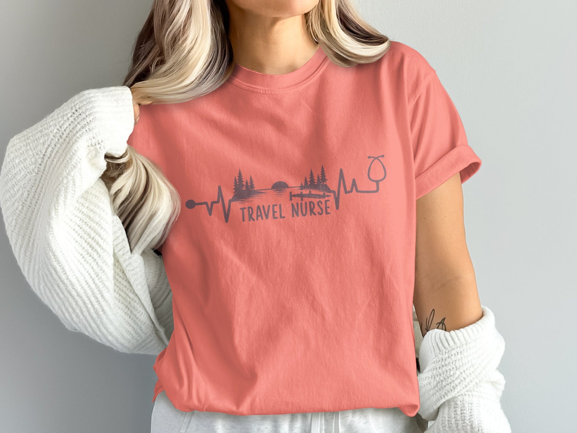 Coral t-shirt with a heartbeat pulse design and "TRAVEL NURSE" text.