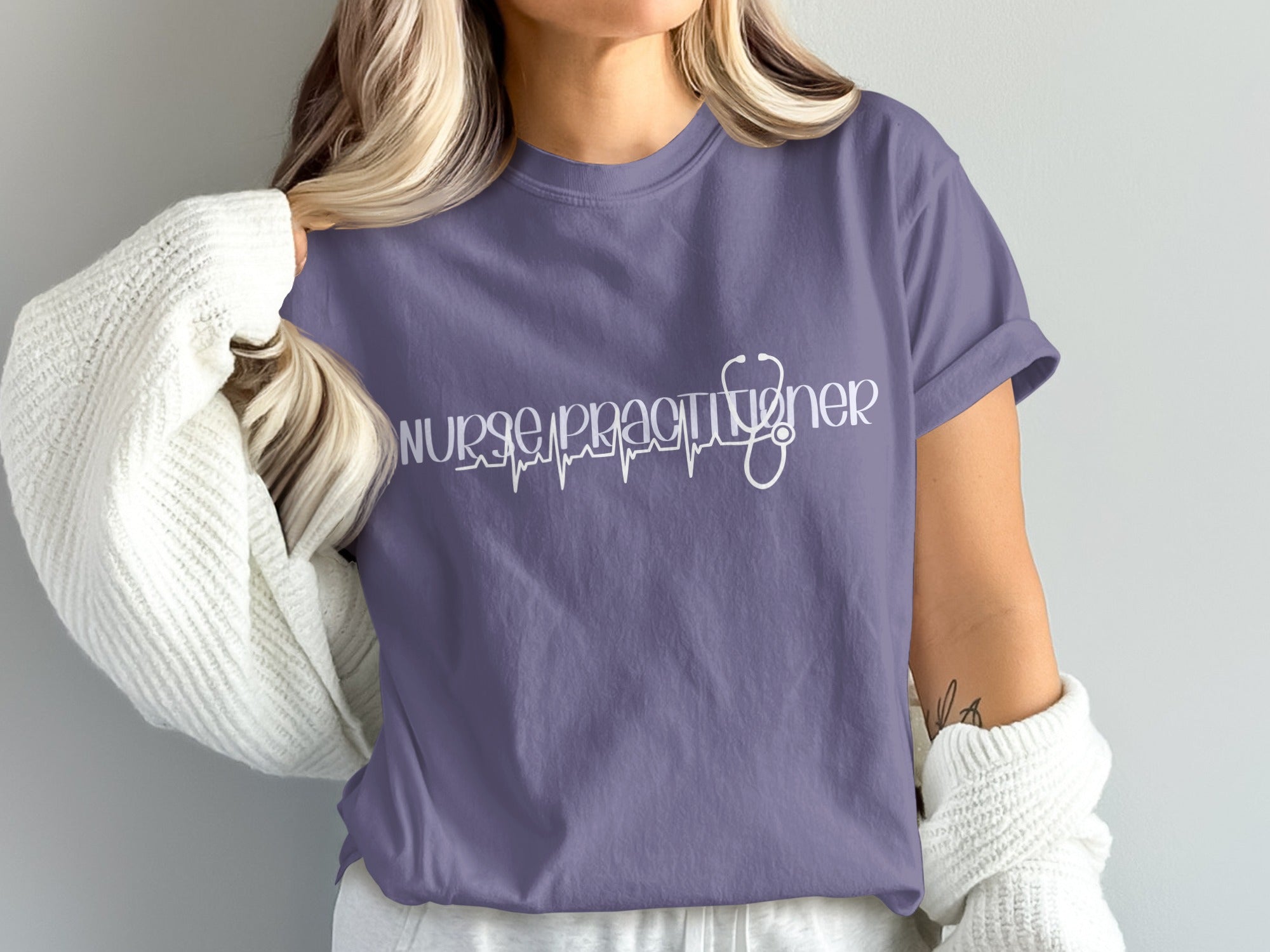 Purple t-shirt with stethoscope and heartbeat graphic text "nurse practitioner".