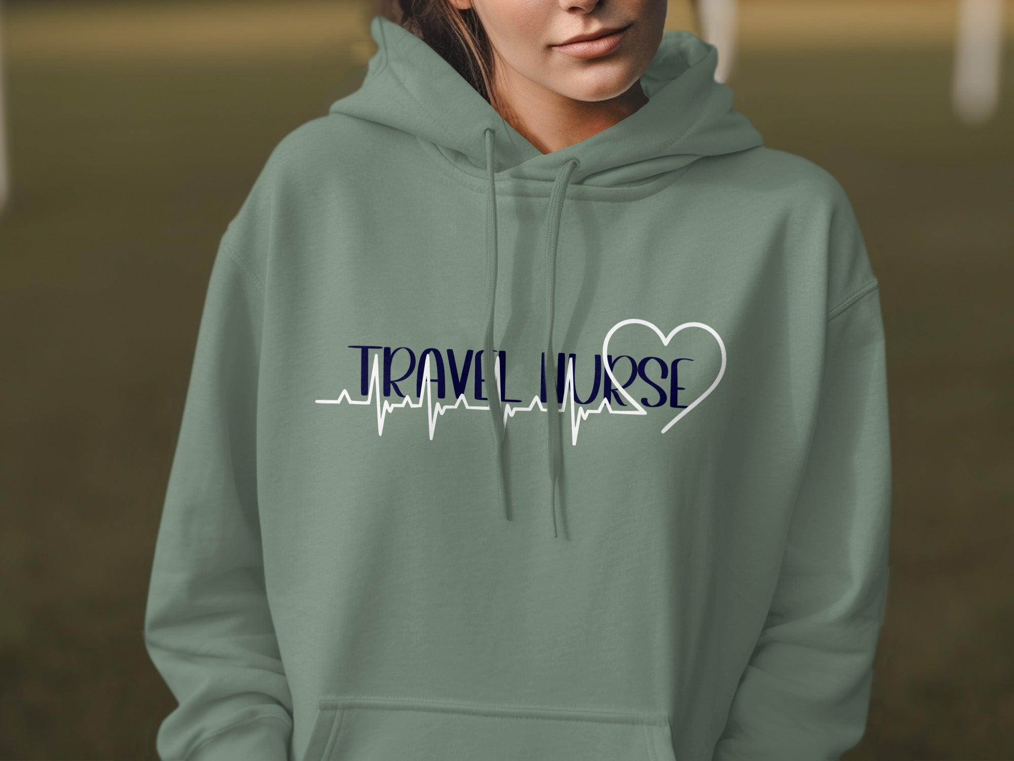 Sage green hoodie with "TRAVEL NURSE" and heart pulse design.