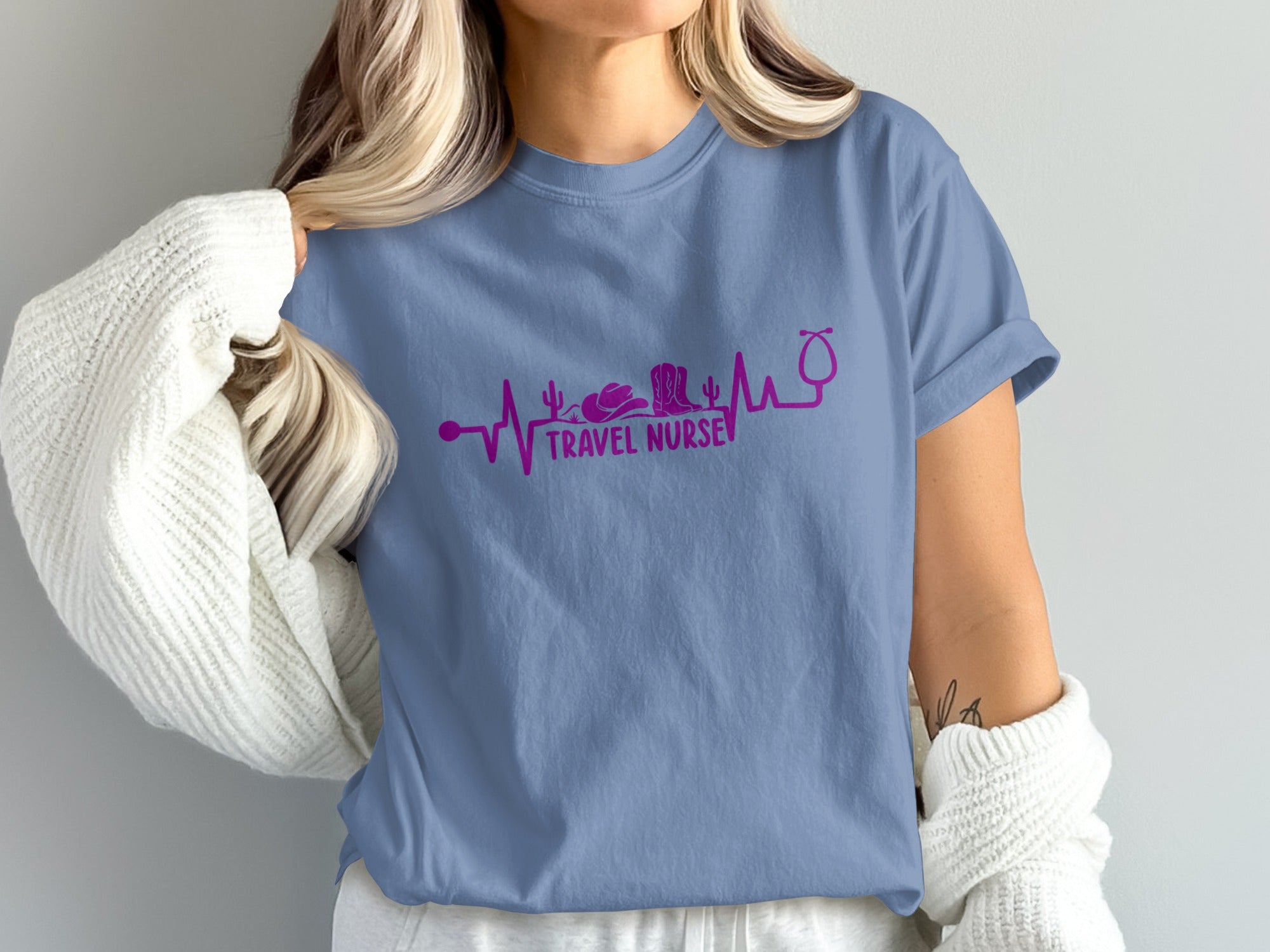 Purple heartbeat graphic with travel nurse icons and text on a blue t-shirt.