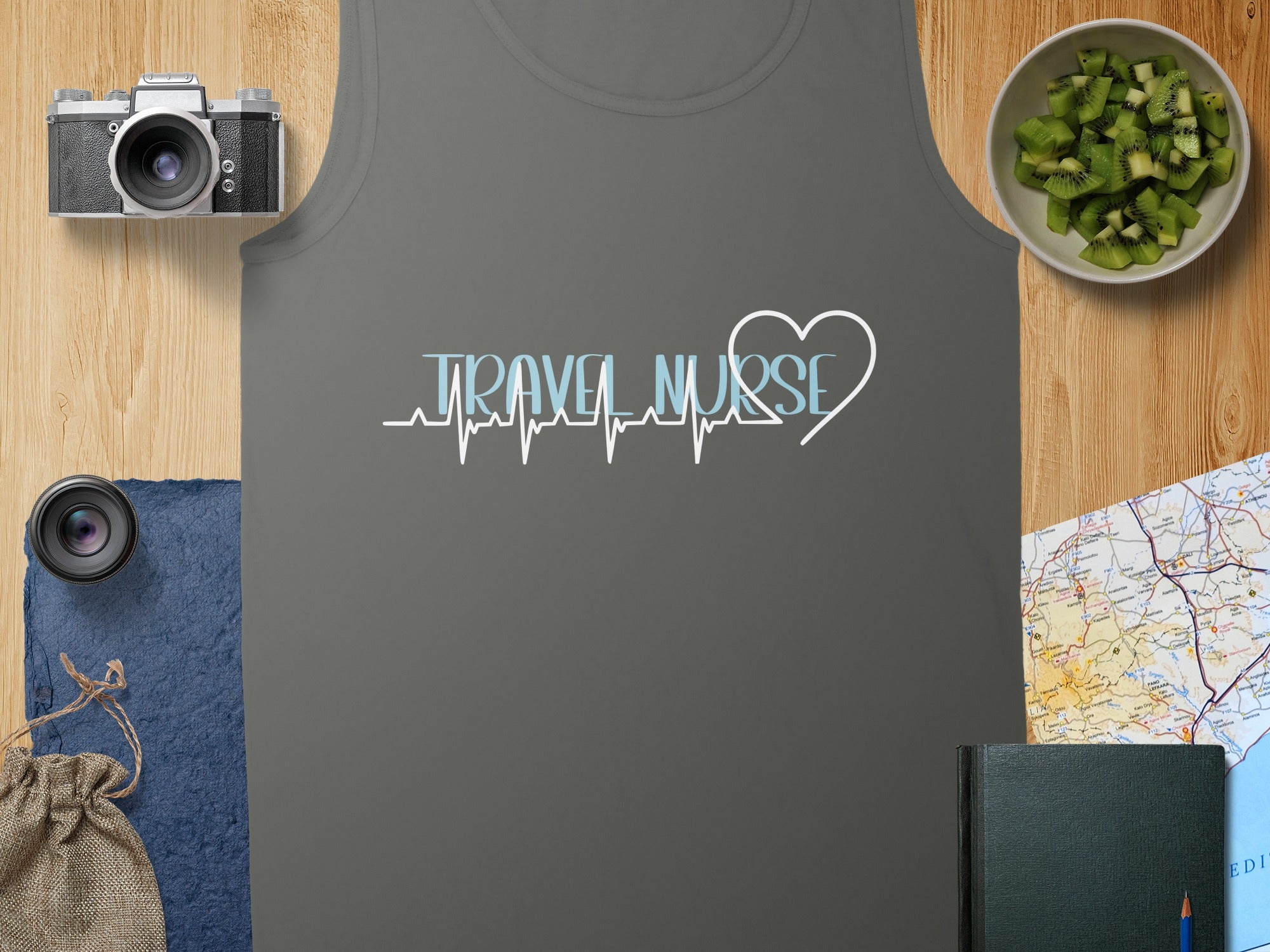 Travel Nurse heart graphic on charcoal tank top with map and kiwi slices.