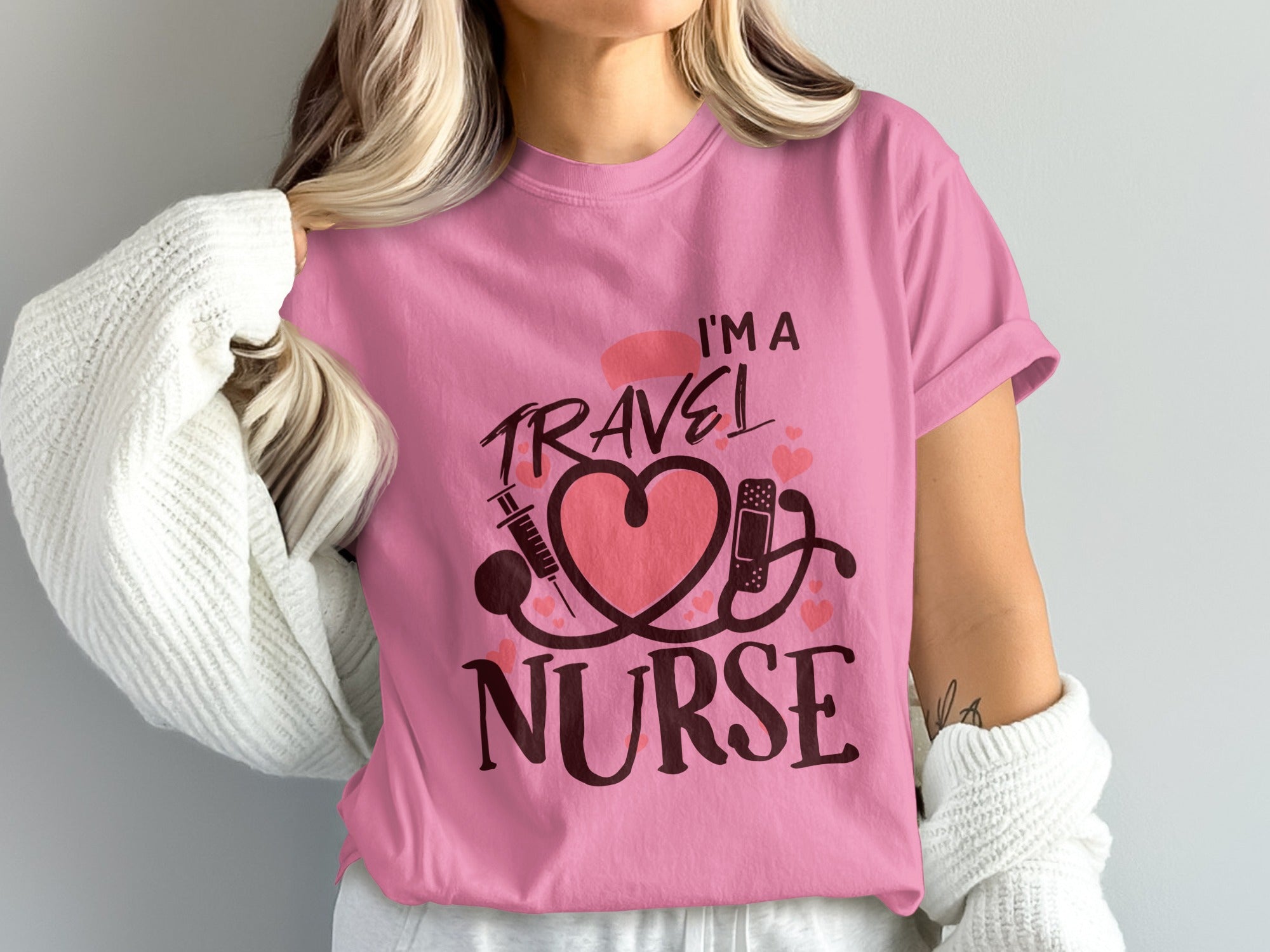 Pink t-shirt with "I'm a Travel Nurse" text, heart, stethoscope, and syringe.