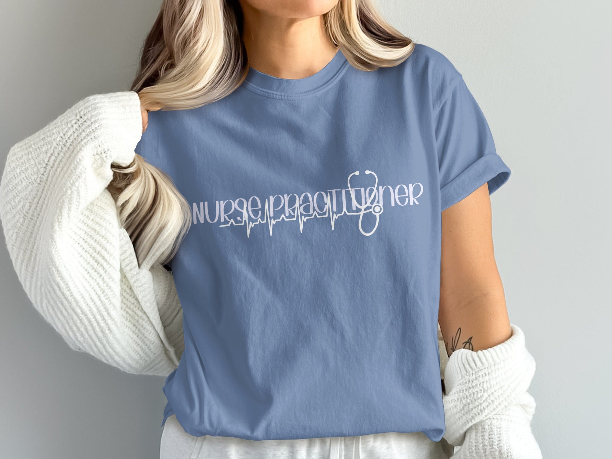 Nurse practitioner text with heartbeat graphic on blue t-shirt.