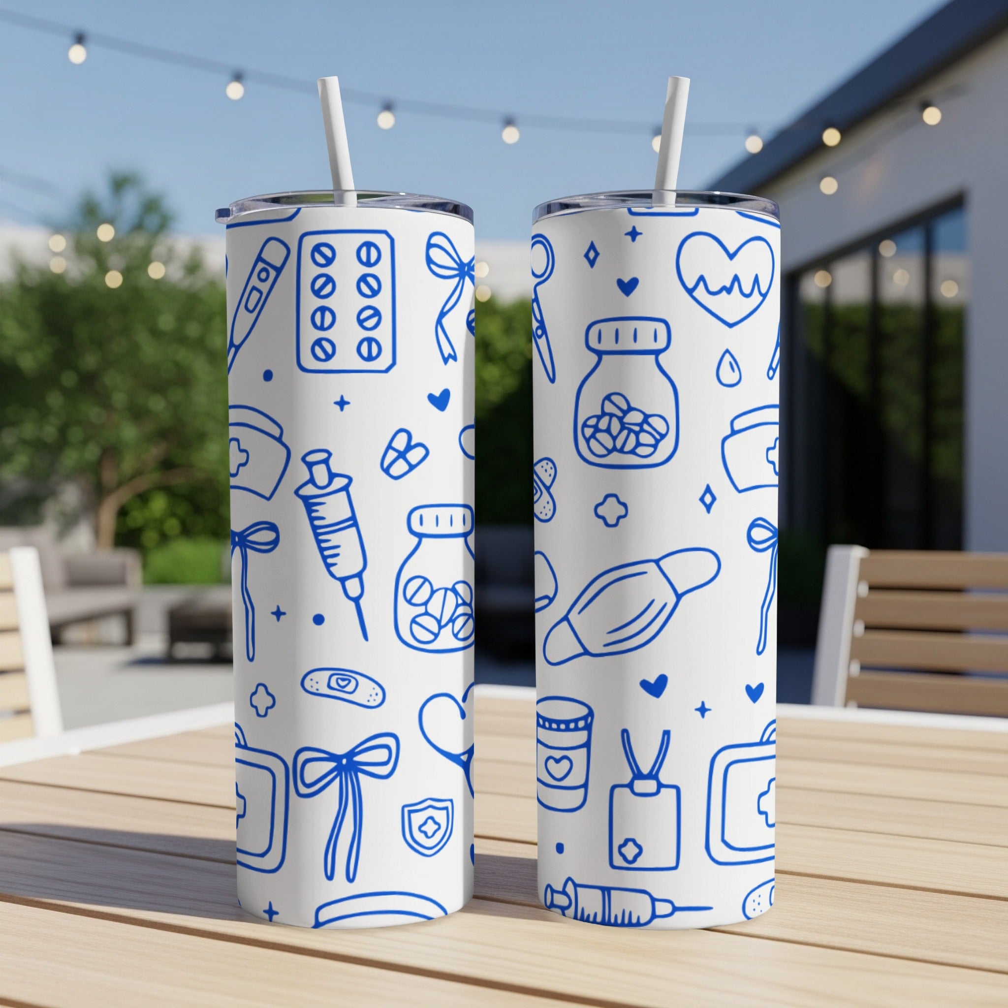 Two white tumblers with a blue medical-themed pattern on a wooden table.