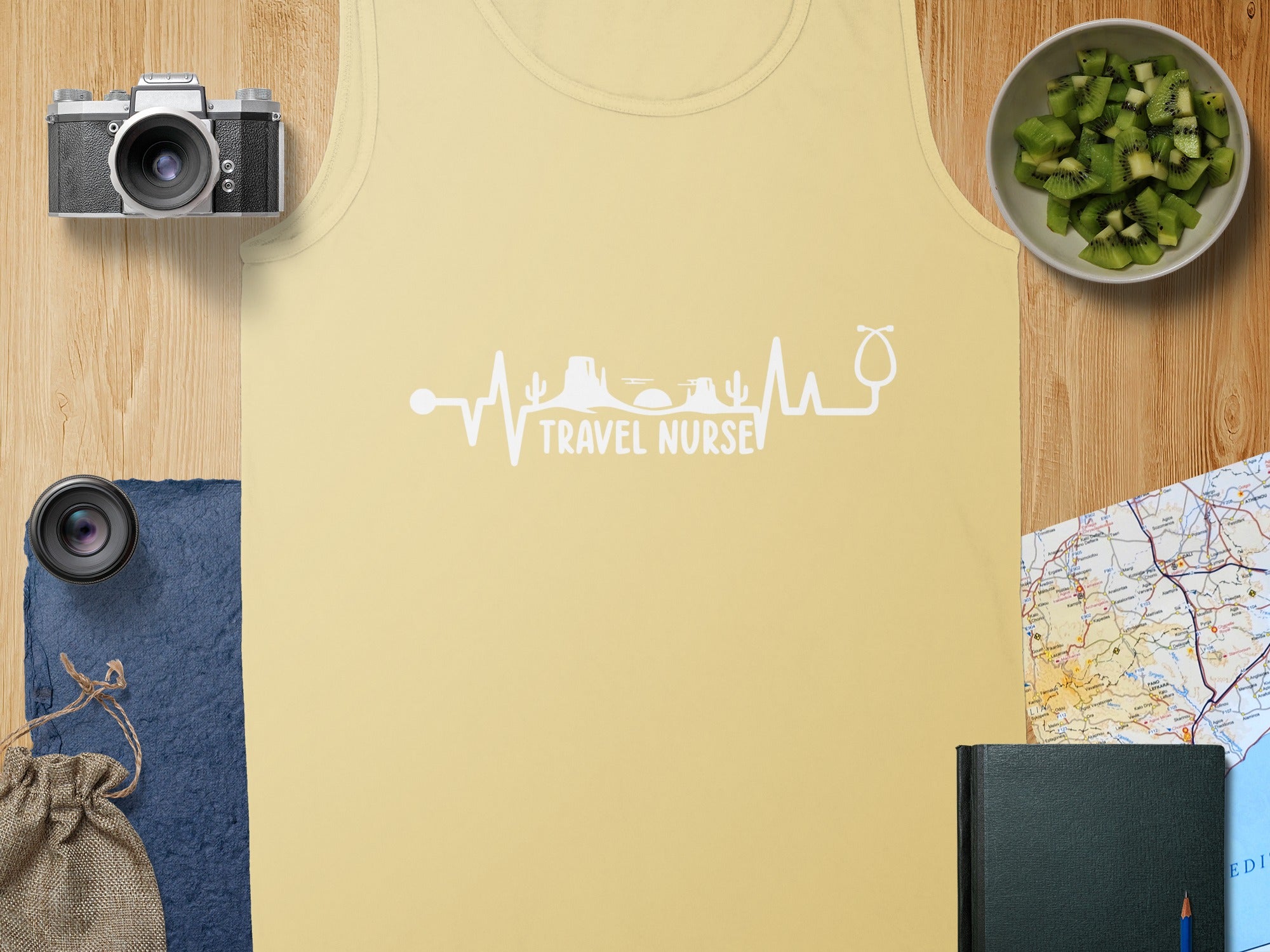 Yellow tank top with "Travel Nurse" electrocardiogram design, camera, and kiwi.