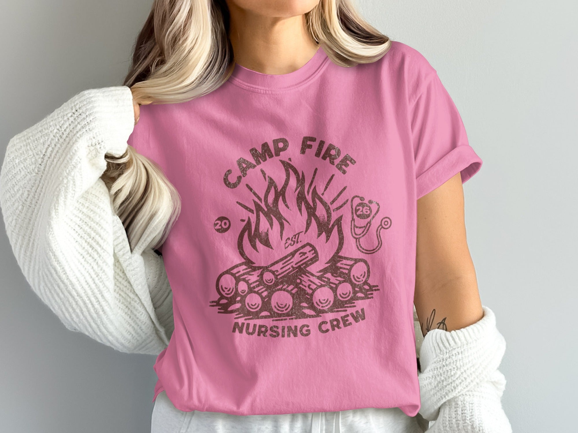 Pink t-shirt with campfire graphic and "Camp Fire Nursing Crew" text.
