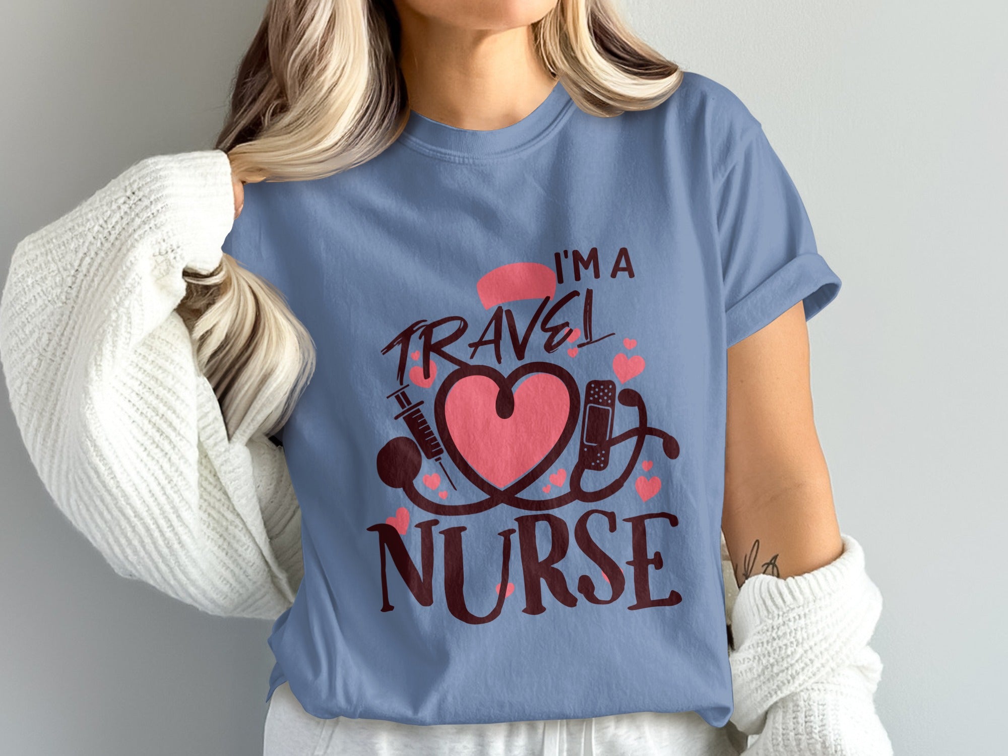 Blue t-shirt with "I'm a Travel Nurse" text, stethoscope, heart, and syringe graphics.